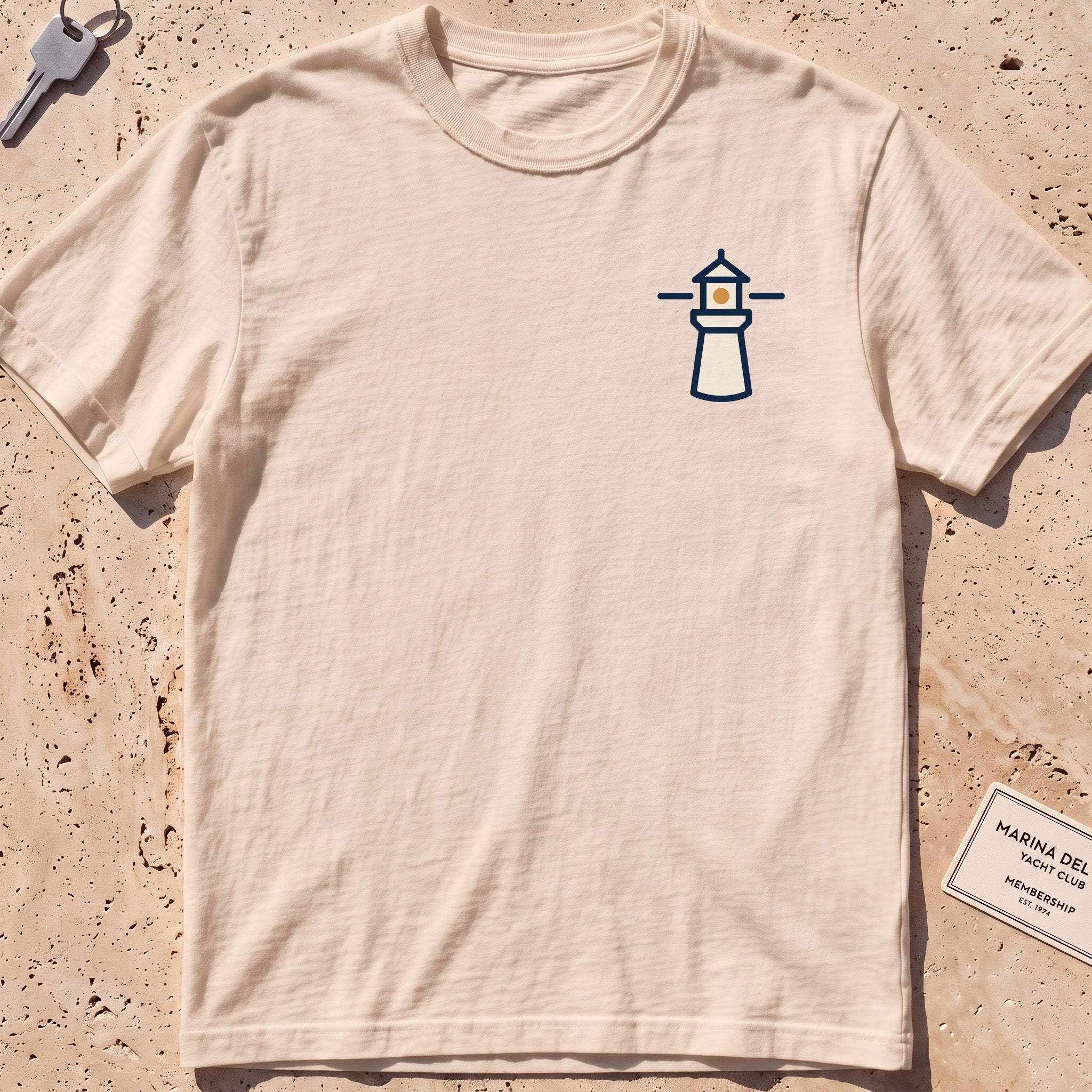 ivory heavyweight tee with a small lighthouse crest graphic.