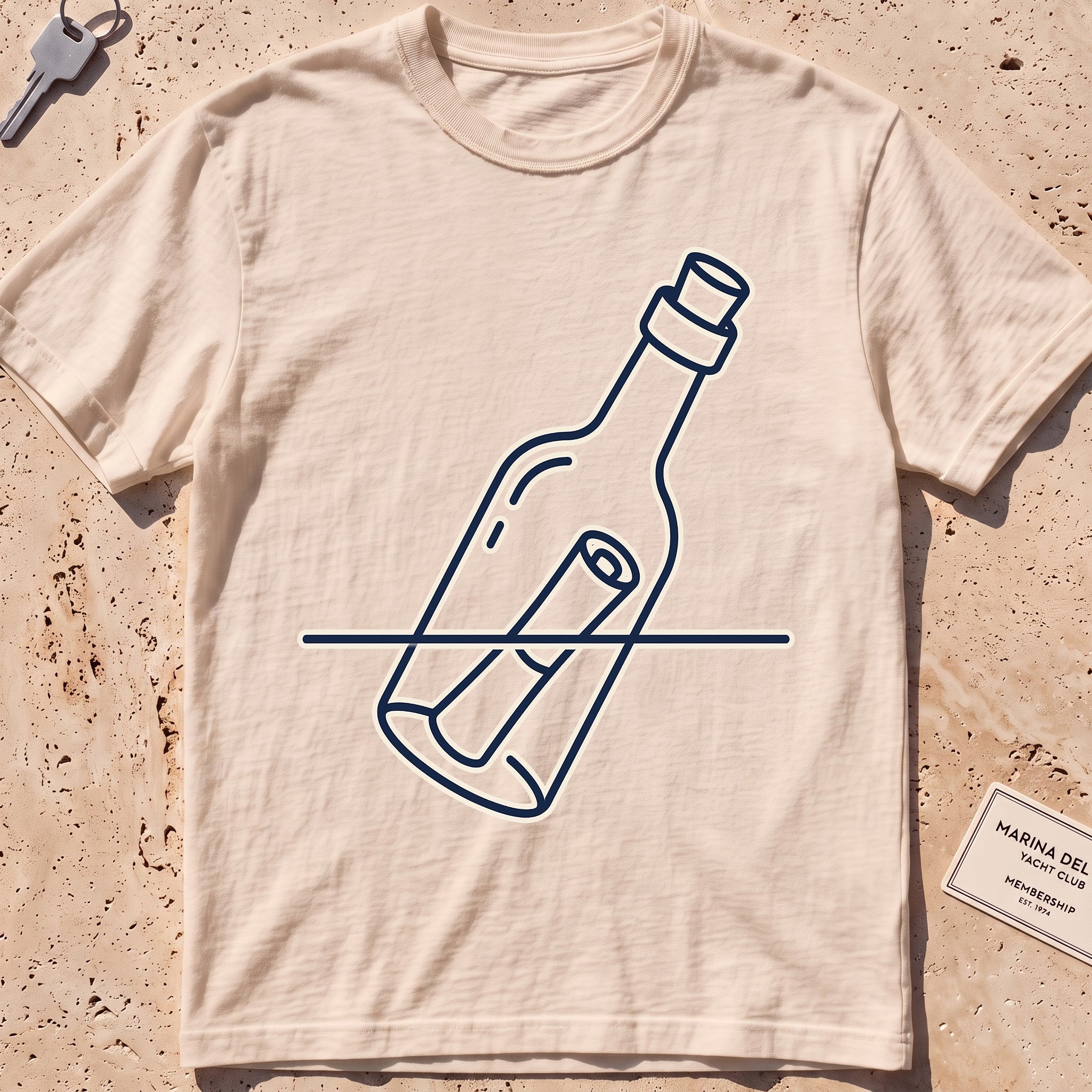 Ivory heavyweight tee with a single-line message-in-a-bottle "Adrift" graphic