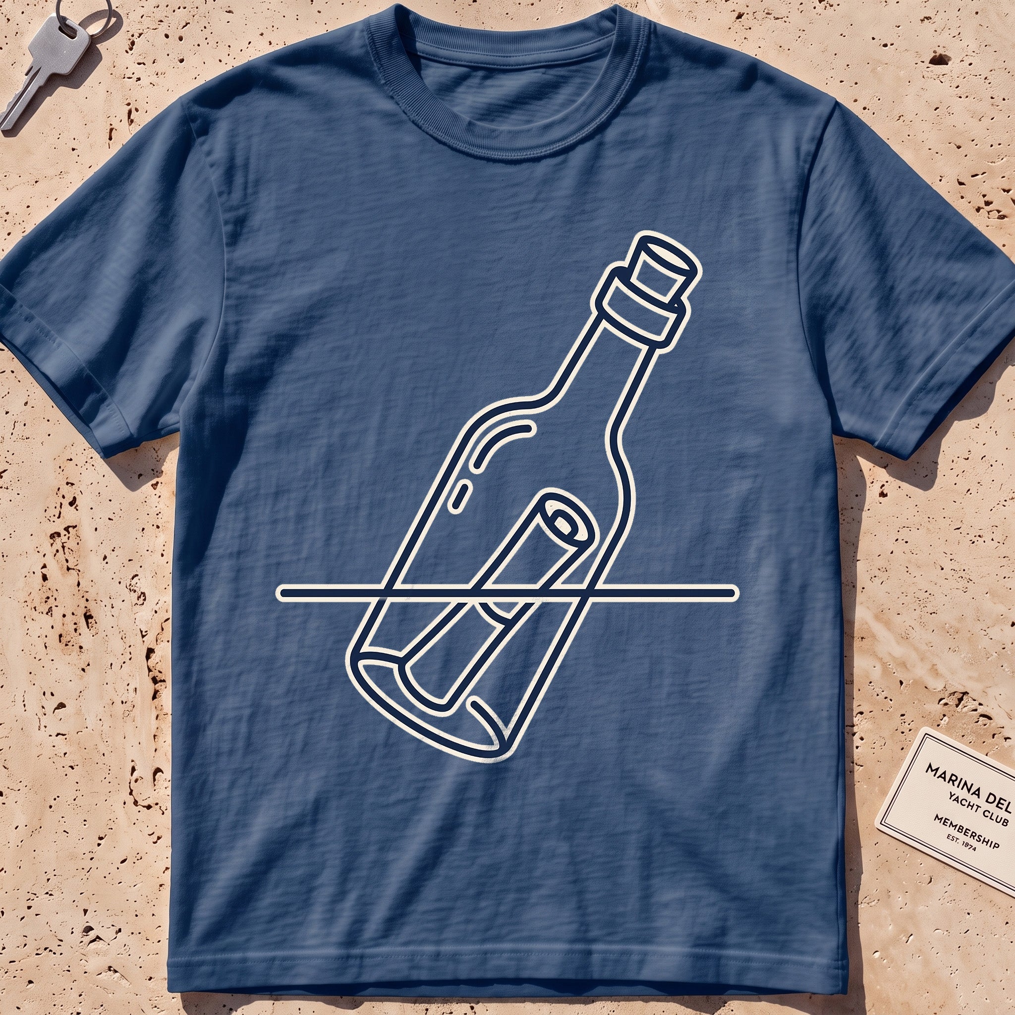 Midnight heavyweight tee with a single-line message-in-a-bottle "Adrift" graphic