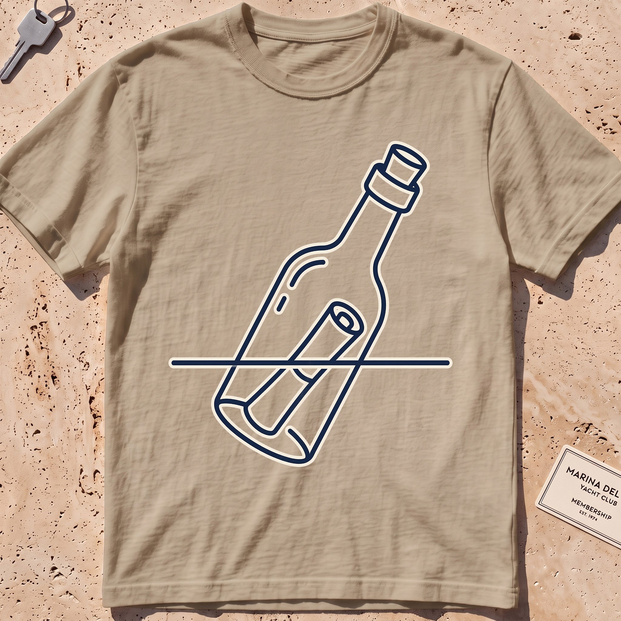 Khaki heavyweight tee with a single-line message-in-a-bottle "Adrift" graphic