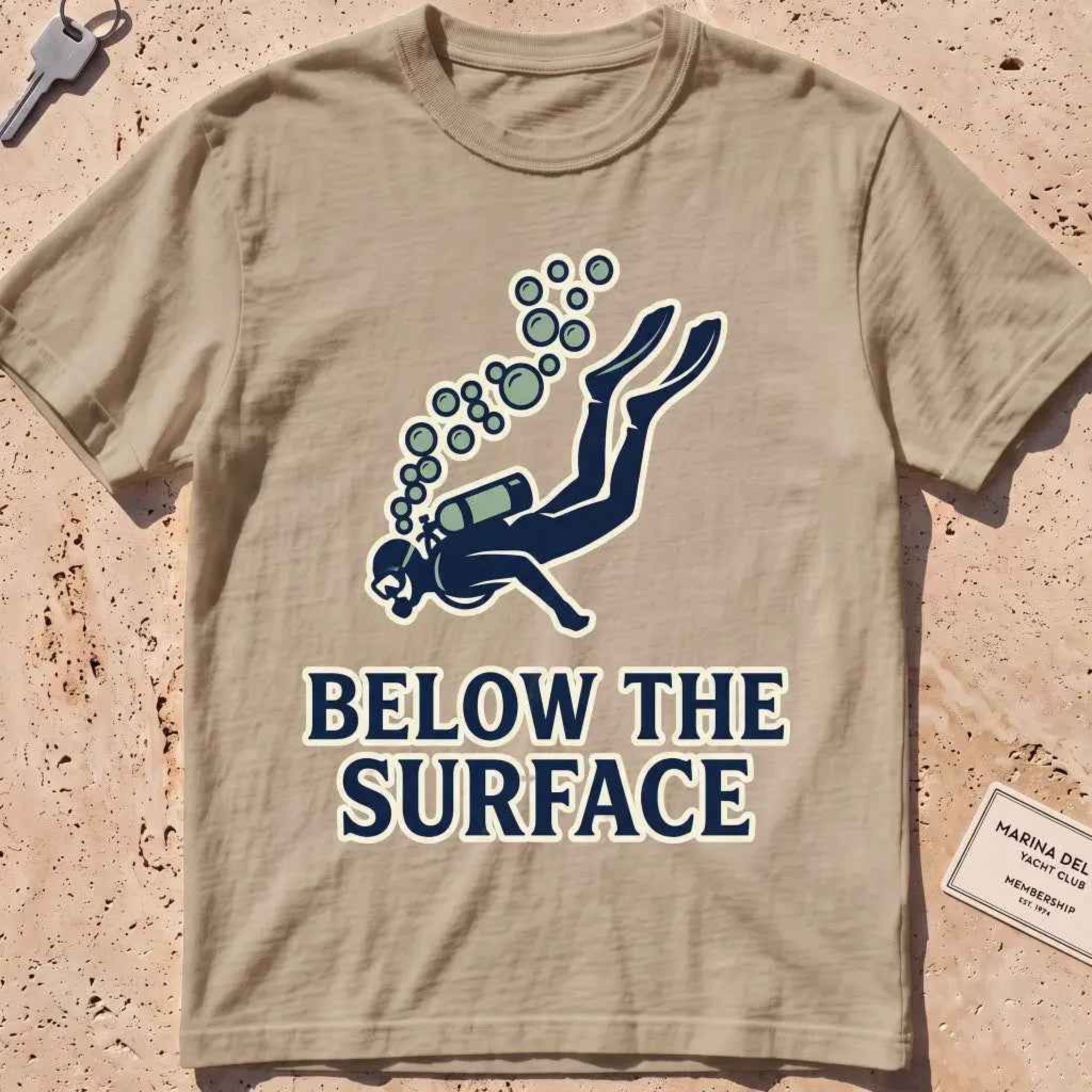 Khaki heavyweight tee with a minimalist scuba diver and rising bubbles graphic.