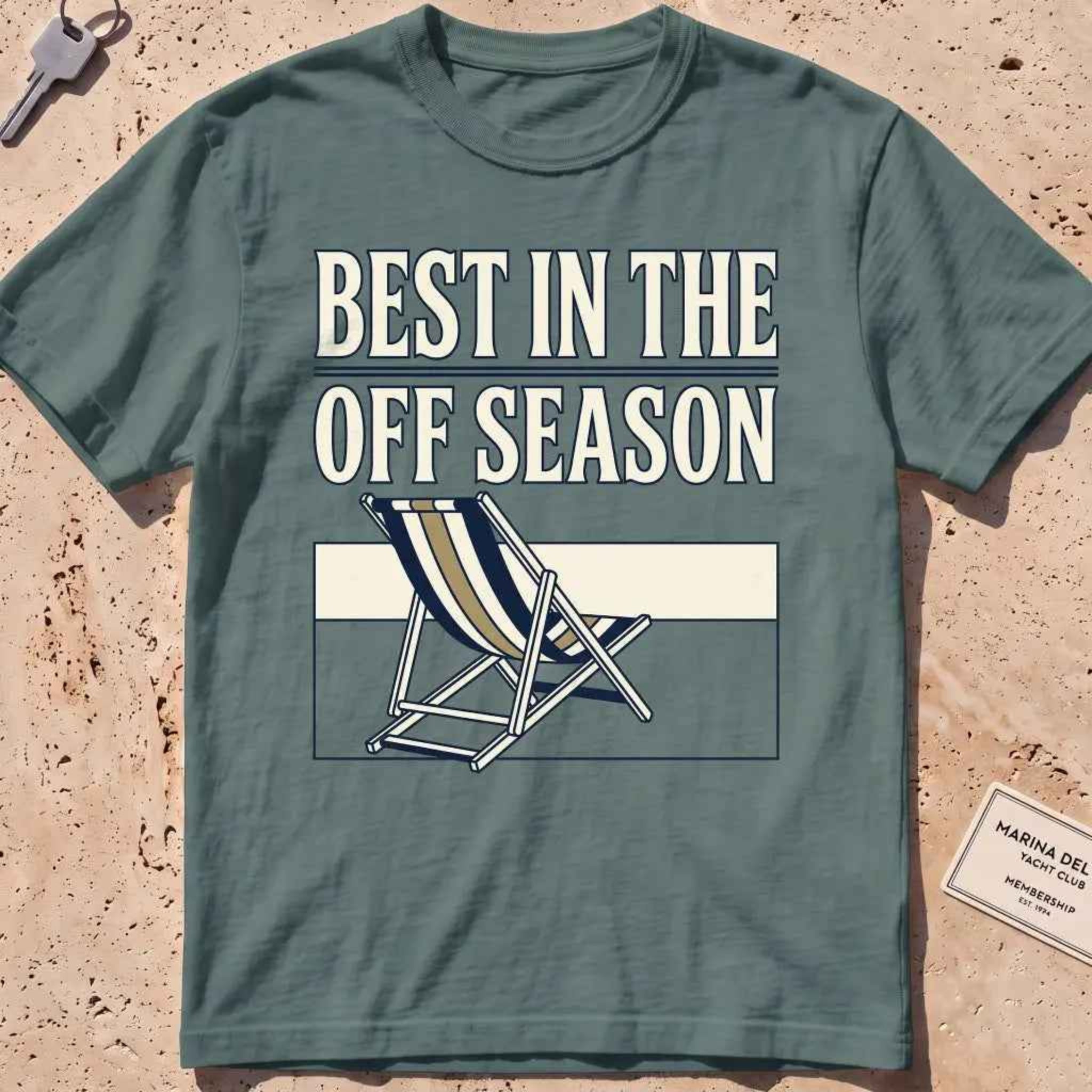 Blue spruce heavyweight tee with "Best in the Off Season" text and an empty deckchair graphic.