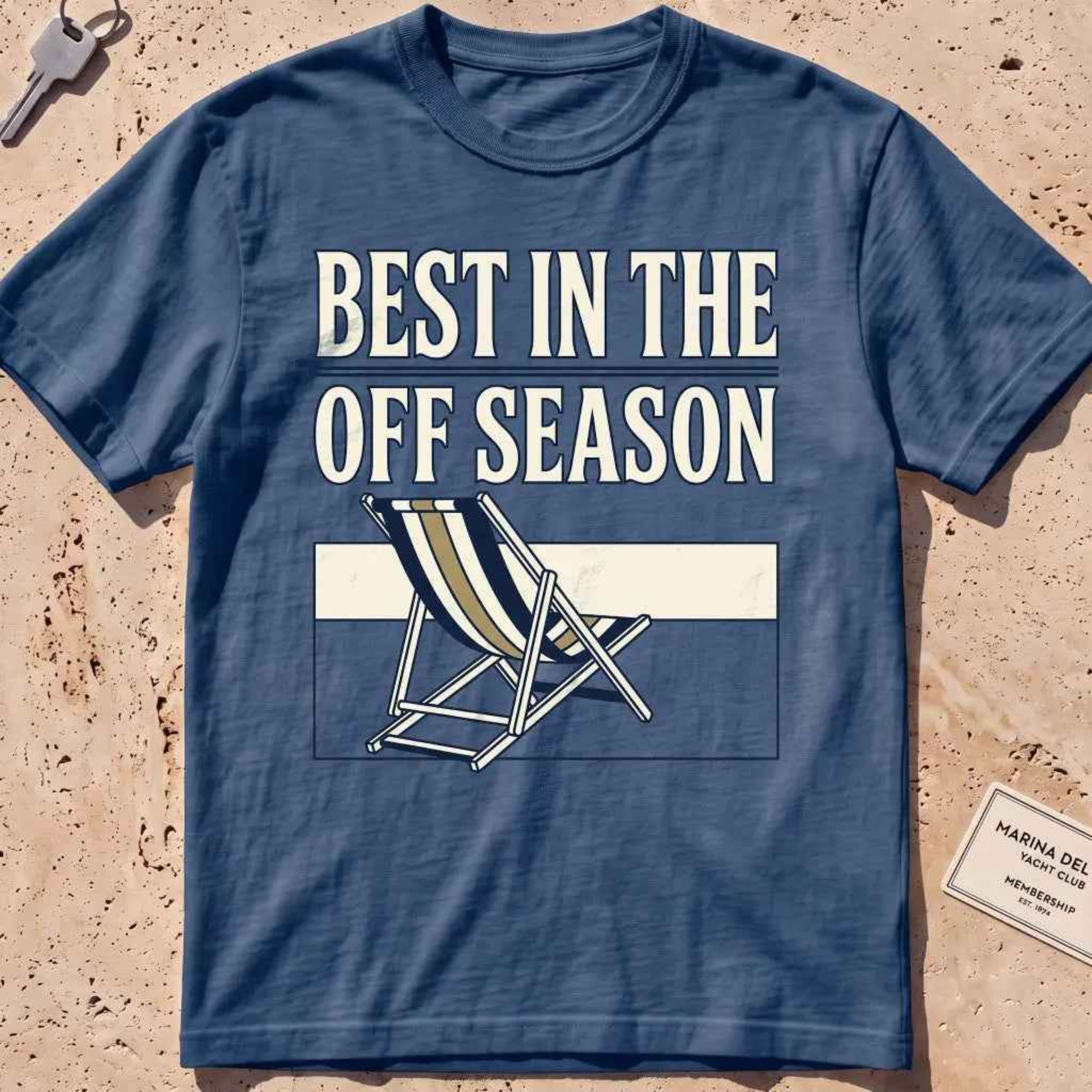 Midnight heavyweight tee with "Best in the Off Season" text and an empty deckchair graphic.
