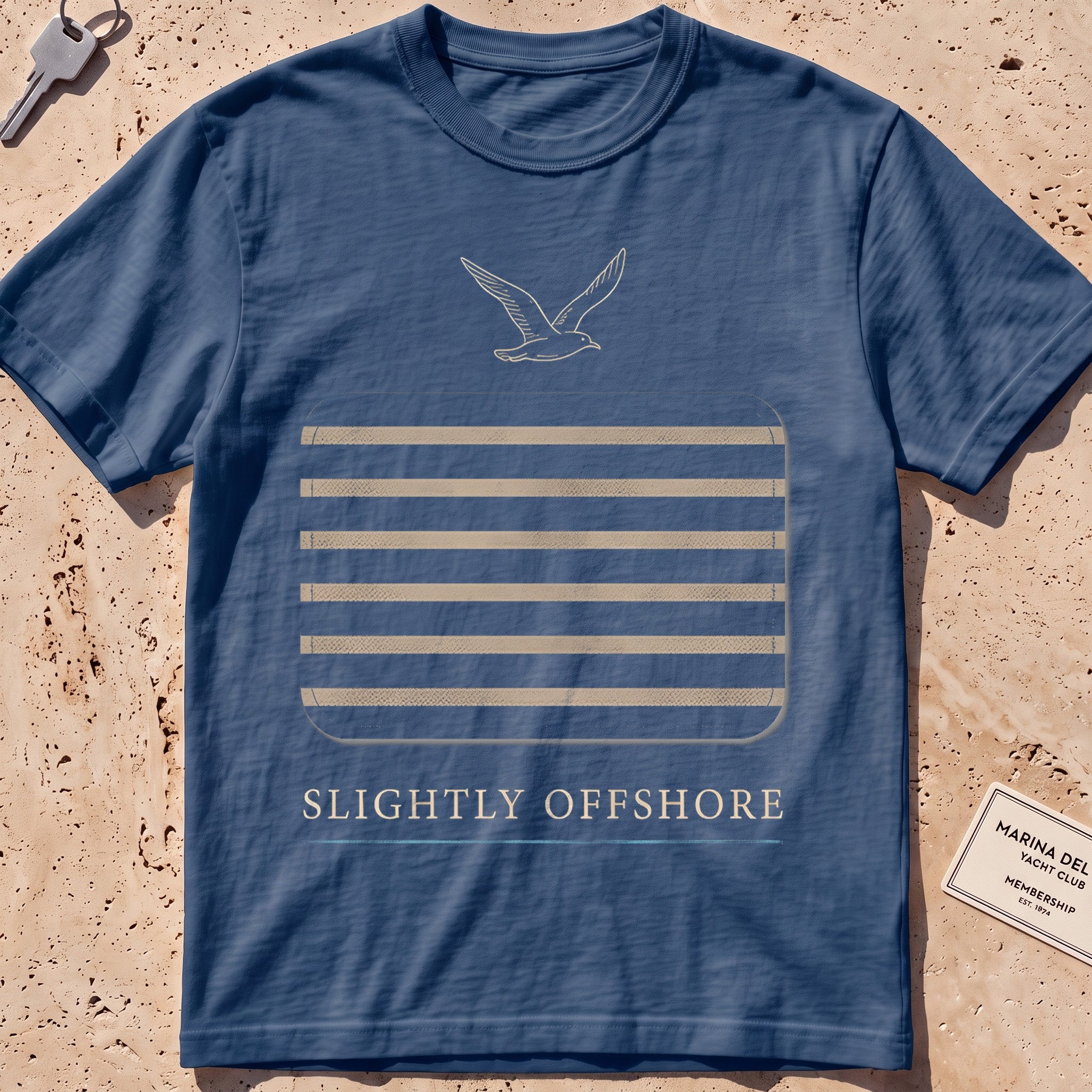 midnight heavyweight tee with a Breton-stripe patch and a small seabird graphic.