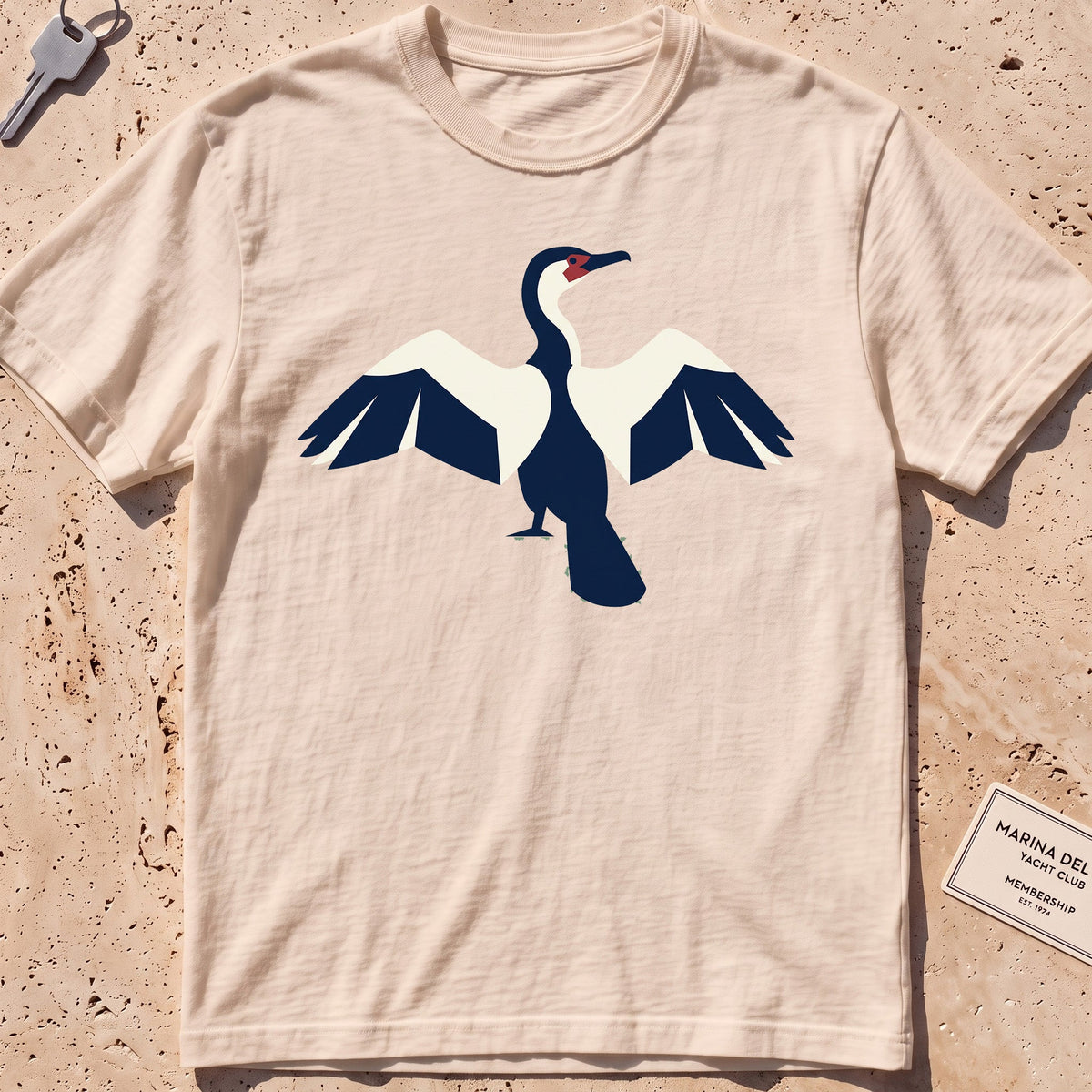 ivory heavyweight tee with a flat-geometric cormorant, wings spread graphic.