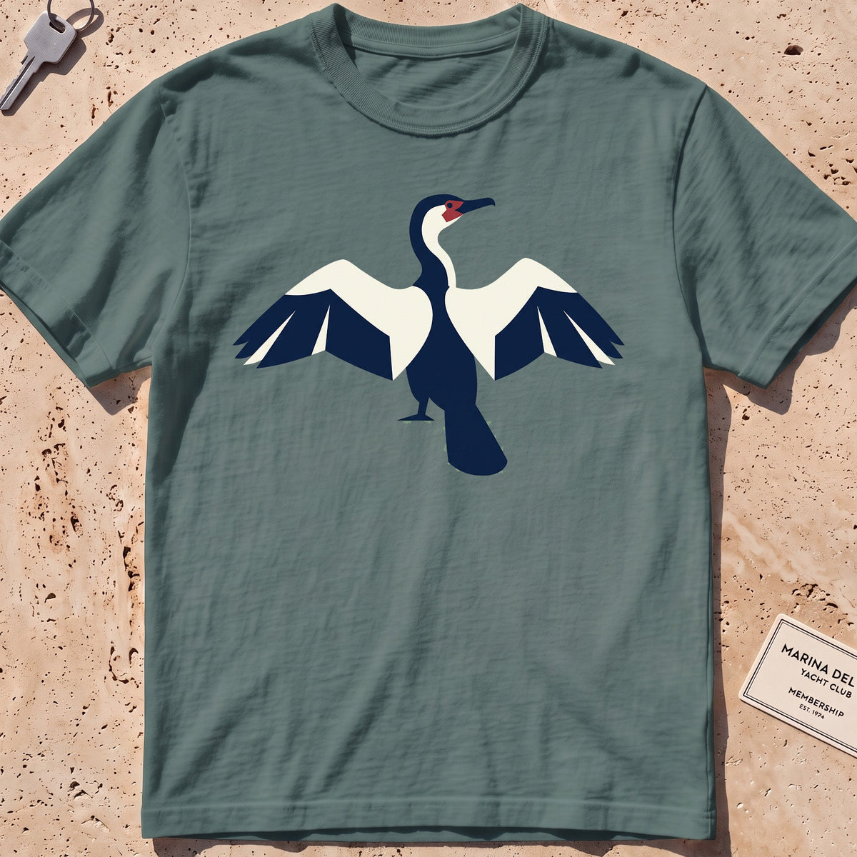blue spruce heavyweight tee with a flat-geometric cormorant, wings spread graphic.