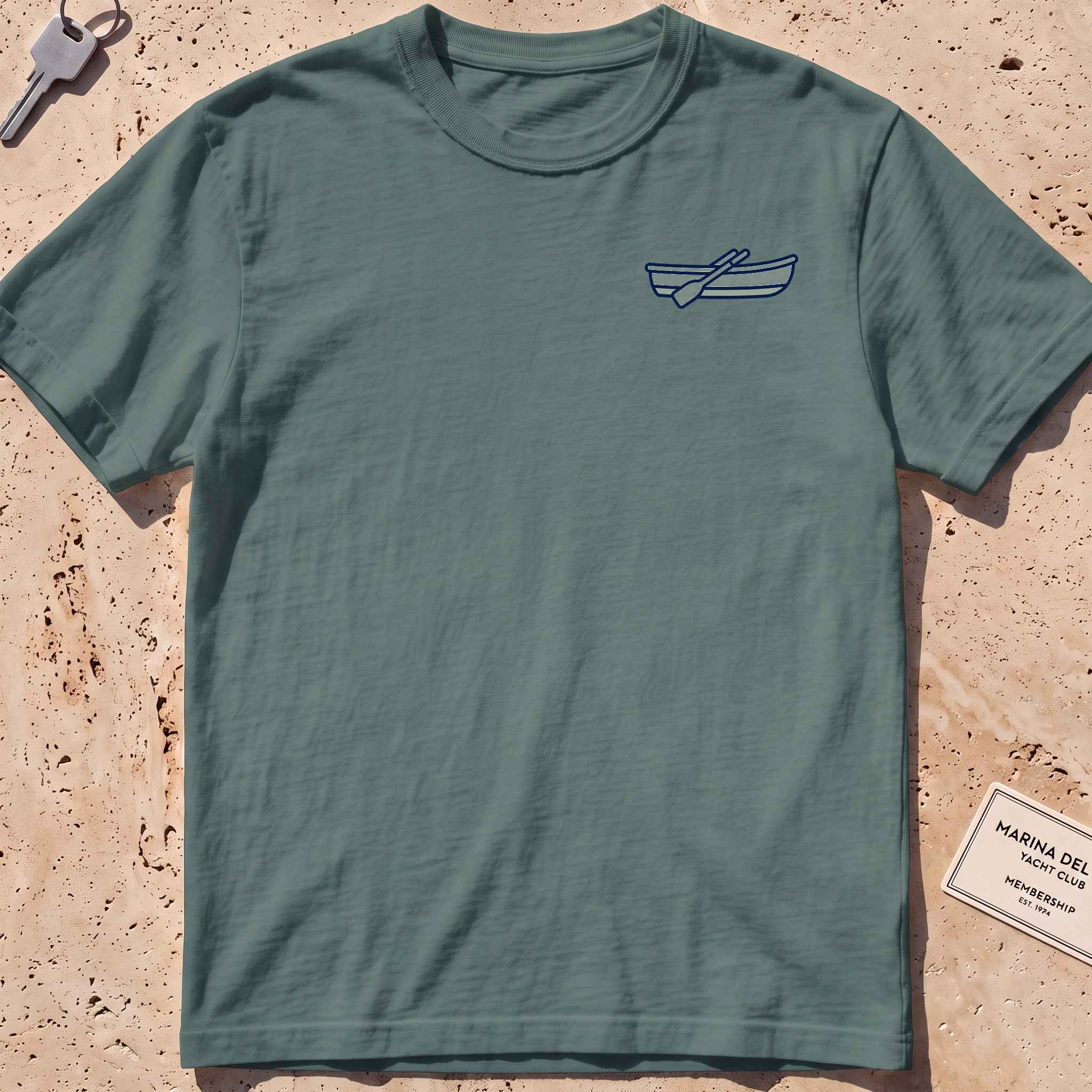 blue spruce heavyweight tee with a rowing-dinghy crest graphic.