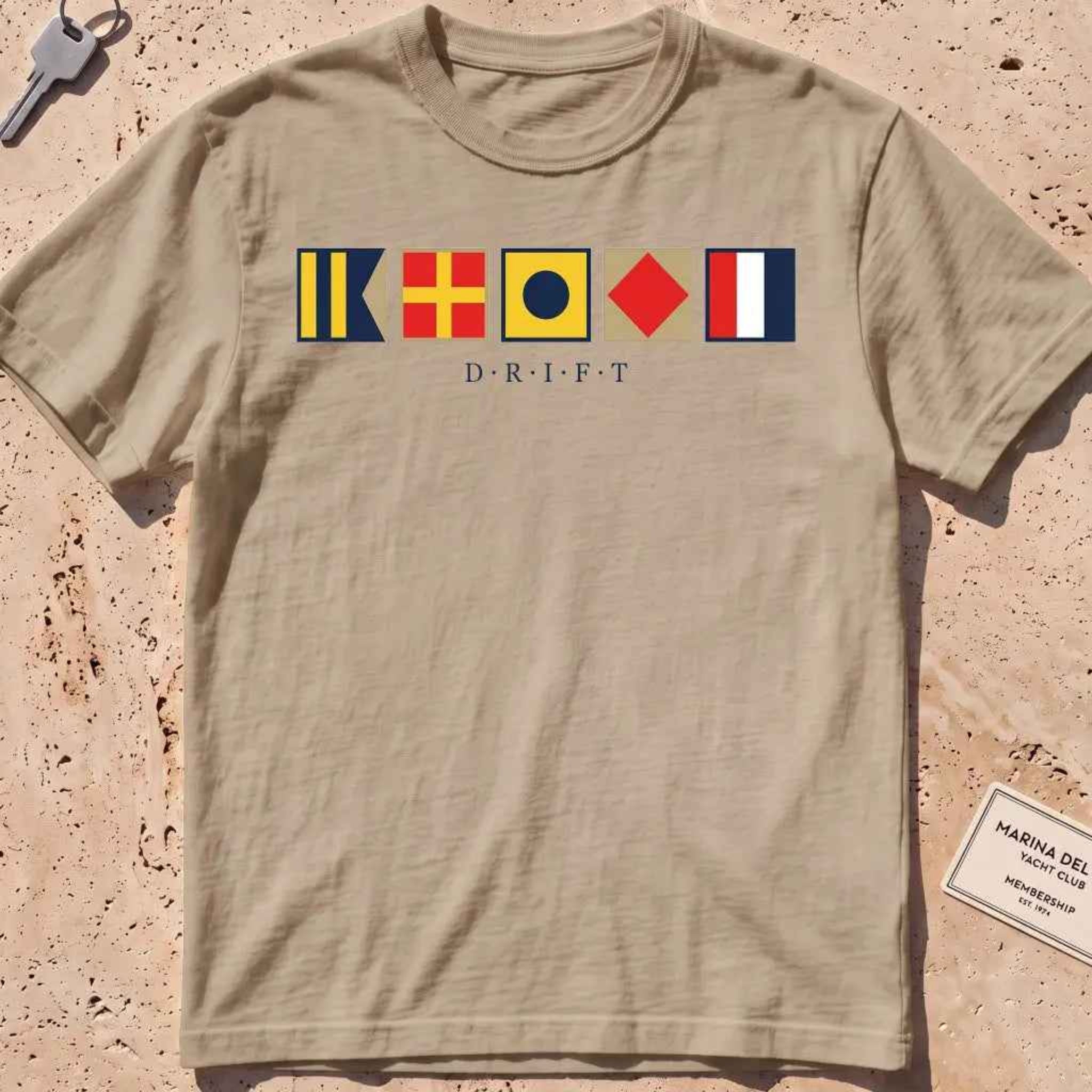Khaki heavyweight tee with maritime signal flags spelling out the word "DRIFT."