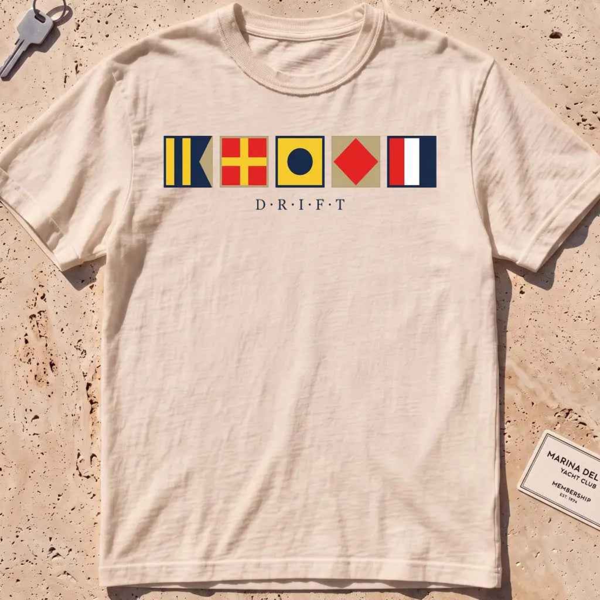 ivory heavyweight tee with maritime signal flags spelling out the word "DRIFT."