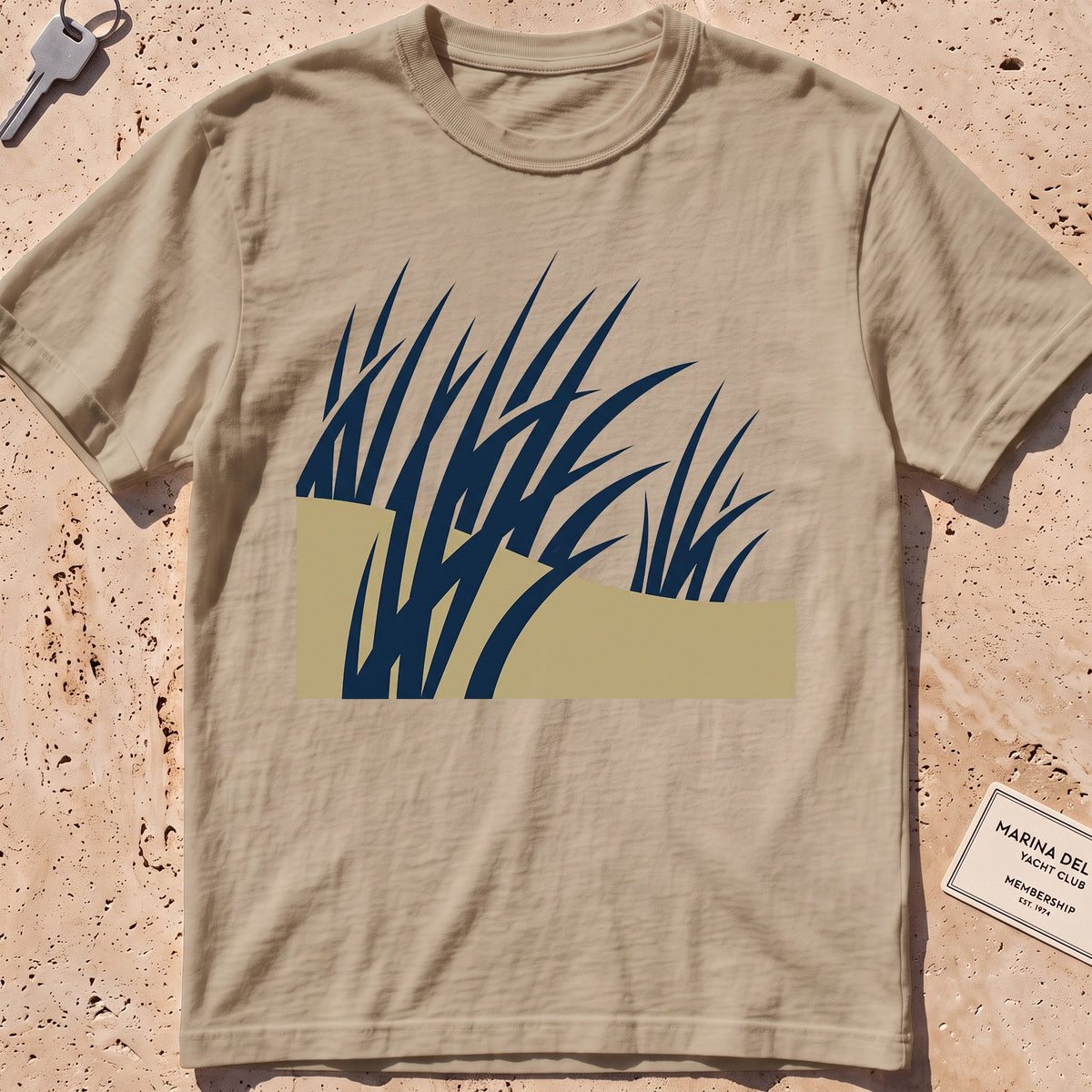 khaki heavyweight tee with flat-geometric wind-bent dune grass graphic.