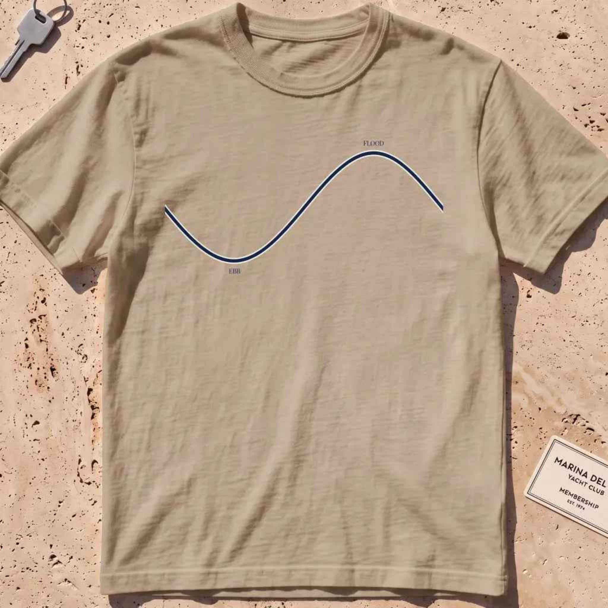 khaki heavyweight tee with a minimalist "Ebb and Flood" tide curve graphic.