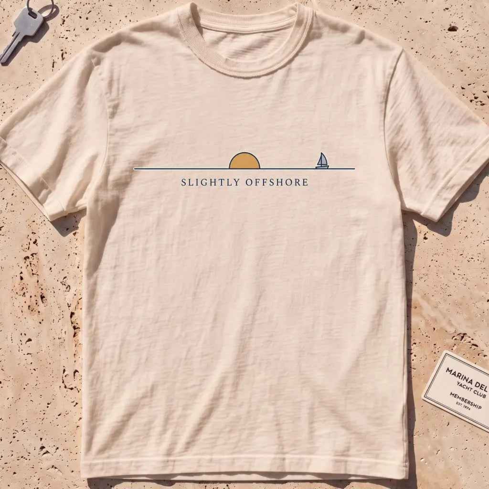 ivory heavyweight tee with an ochre half-sun, horizon line and tiny sailboat.