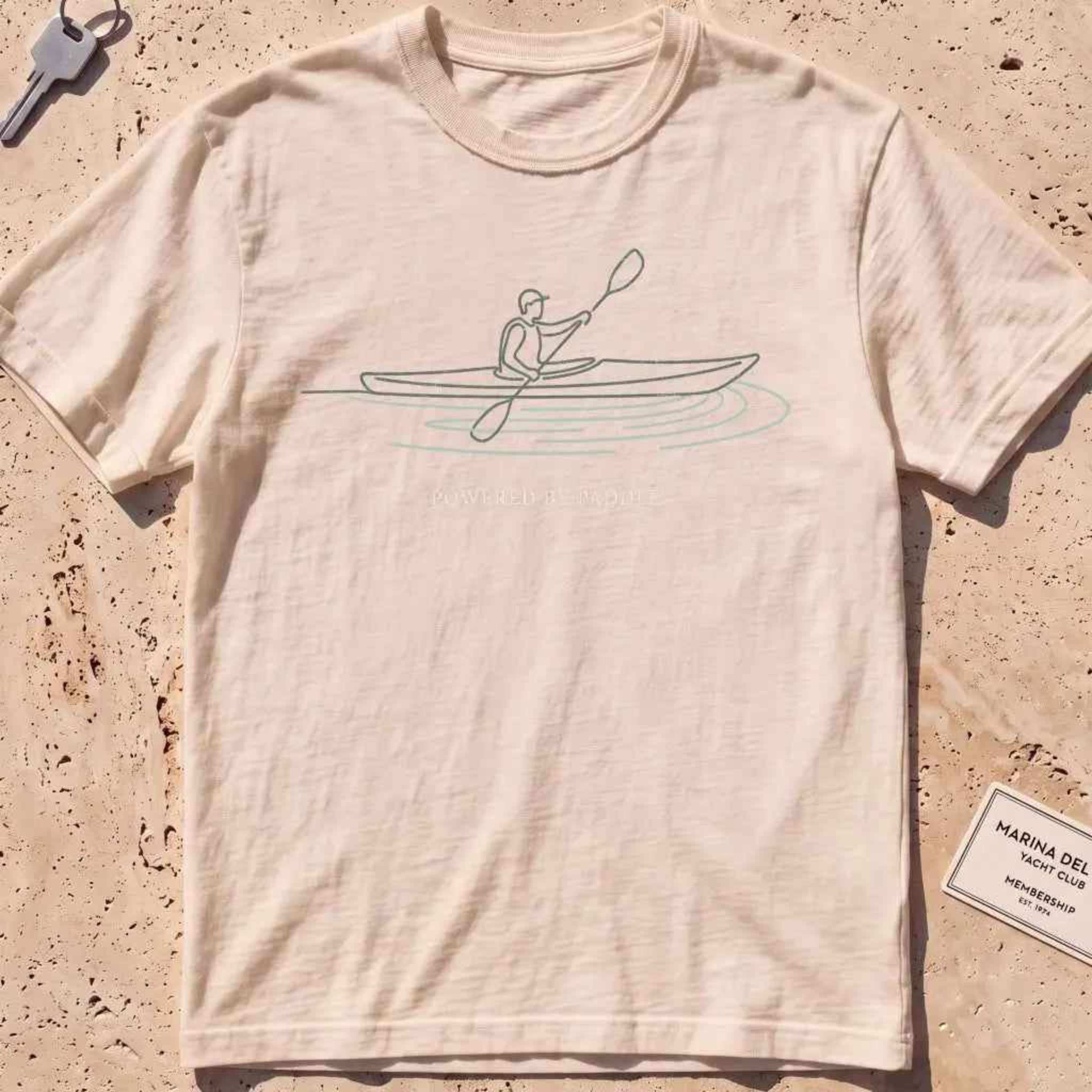 ivory heavyweight tee with a single-line kayaker "Powered by Paddle" graphic.