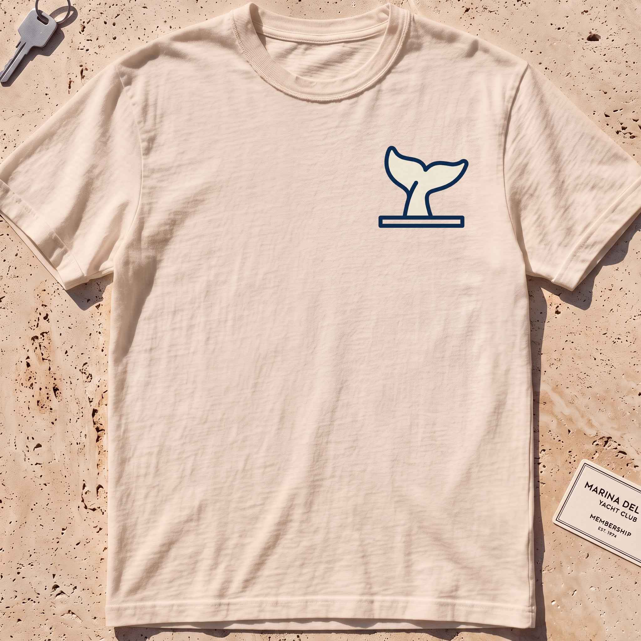 ivory heavyweight tee with a diving whale-fluke crest graphic.