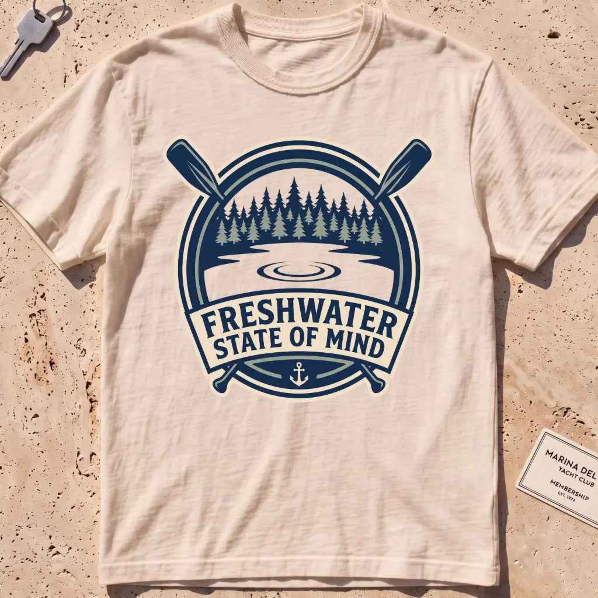 ivory heavyweight tee with a lake-and-pines "Freshwater State of Mind" crest.