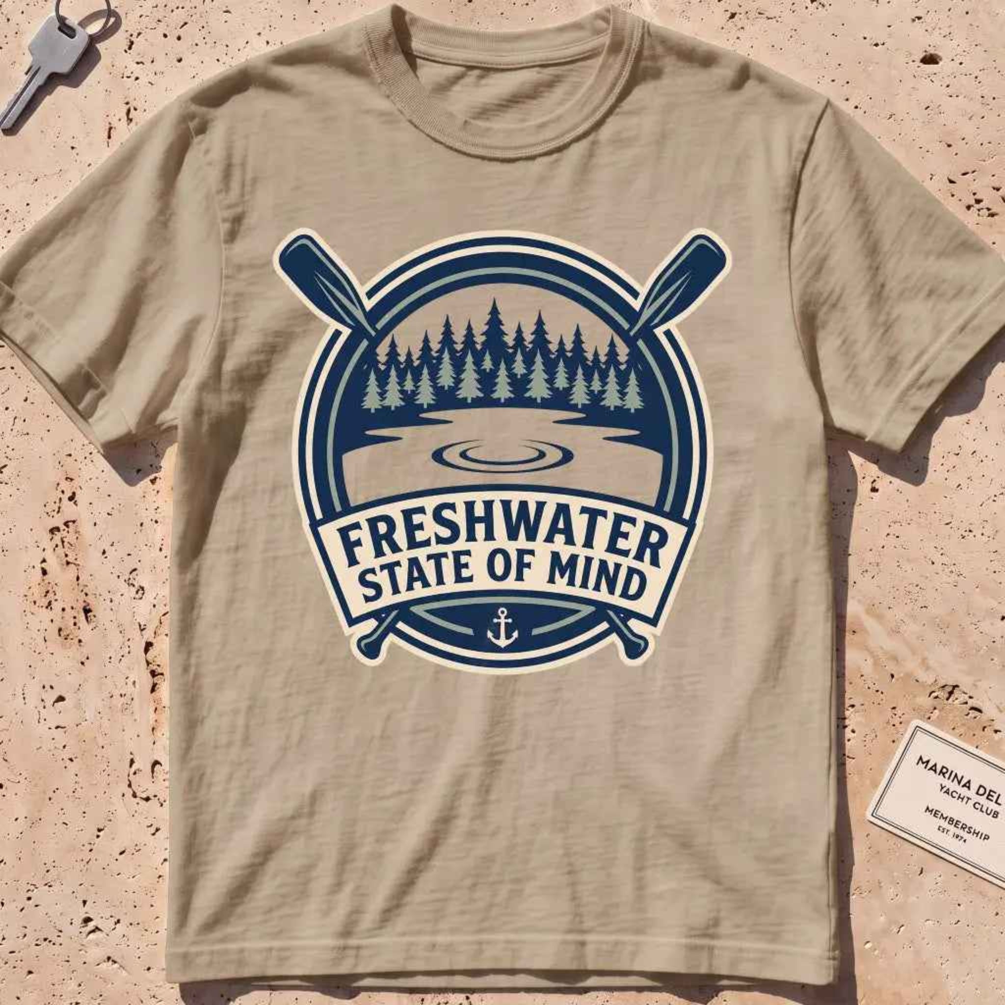 khaki heavyweight tee with a lake-and-pines "Freshwater State of Mind" crest.