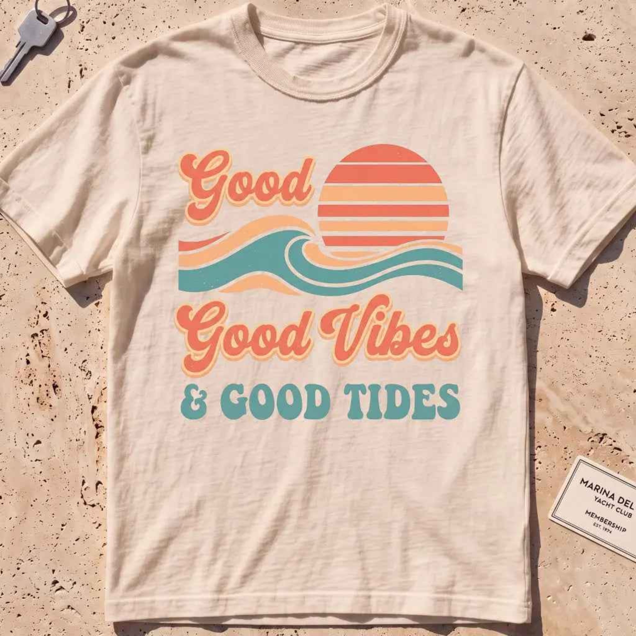 ivory heavyweight tee with retro "Good Vibes and Good Tides" sun-and-wave script.