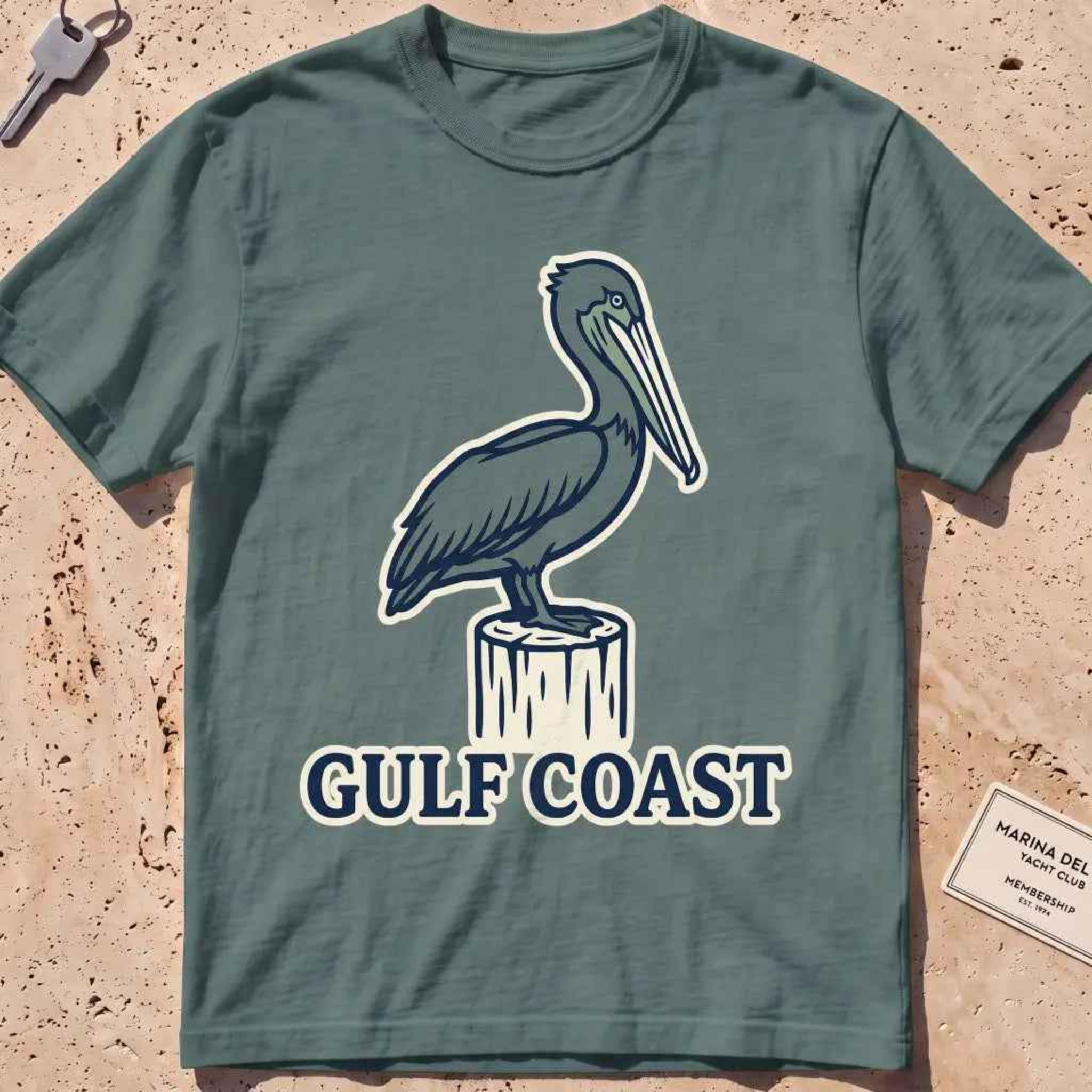 blue spruce heavyweight tee with a pelican perched on a dock piling graphic.