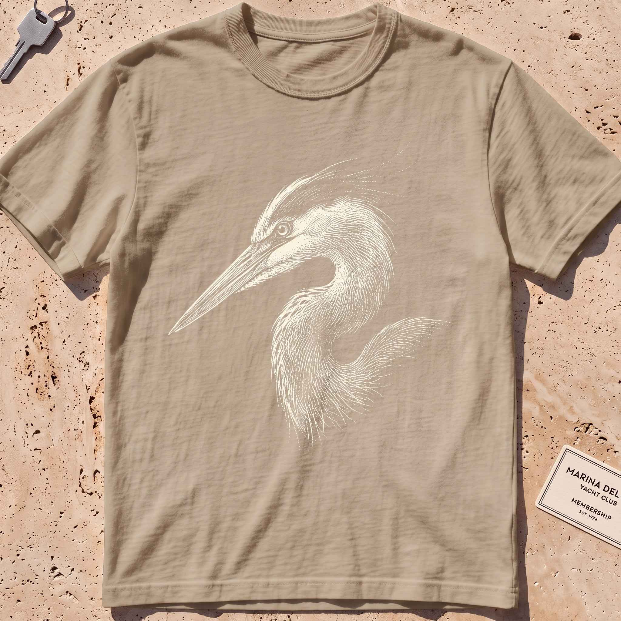khaki heavyweight tee with an etched heron-head portrait graphic.