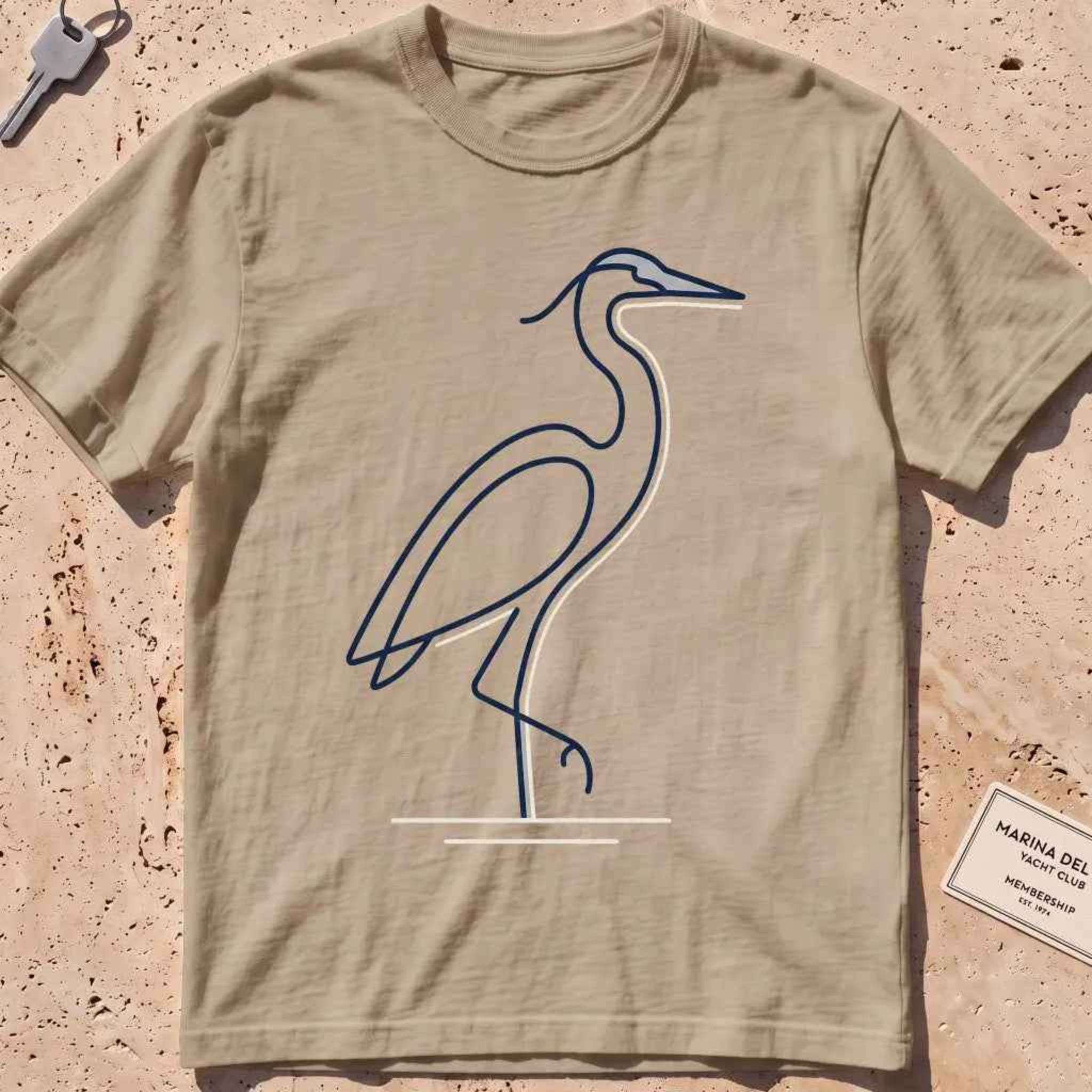 khaki heavyweight tee with a single continuous-line heron standing still graphic.