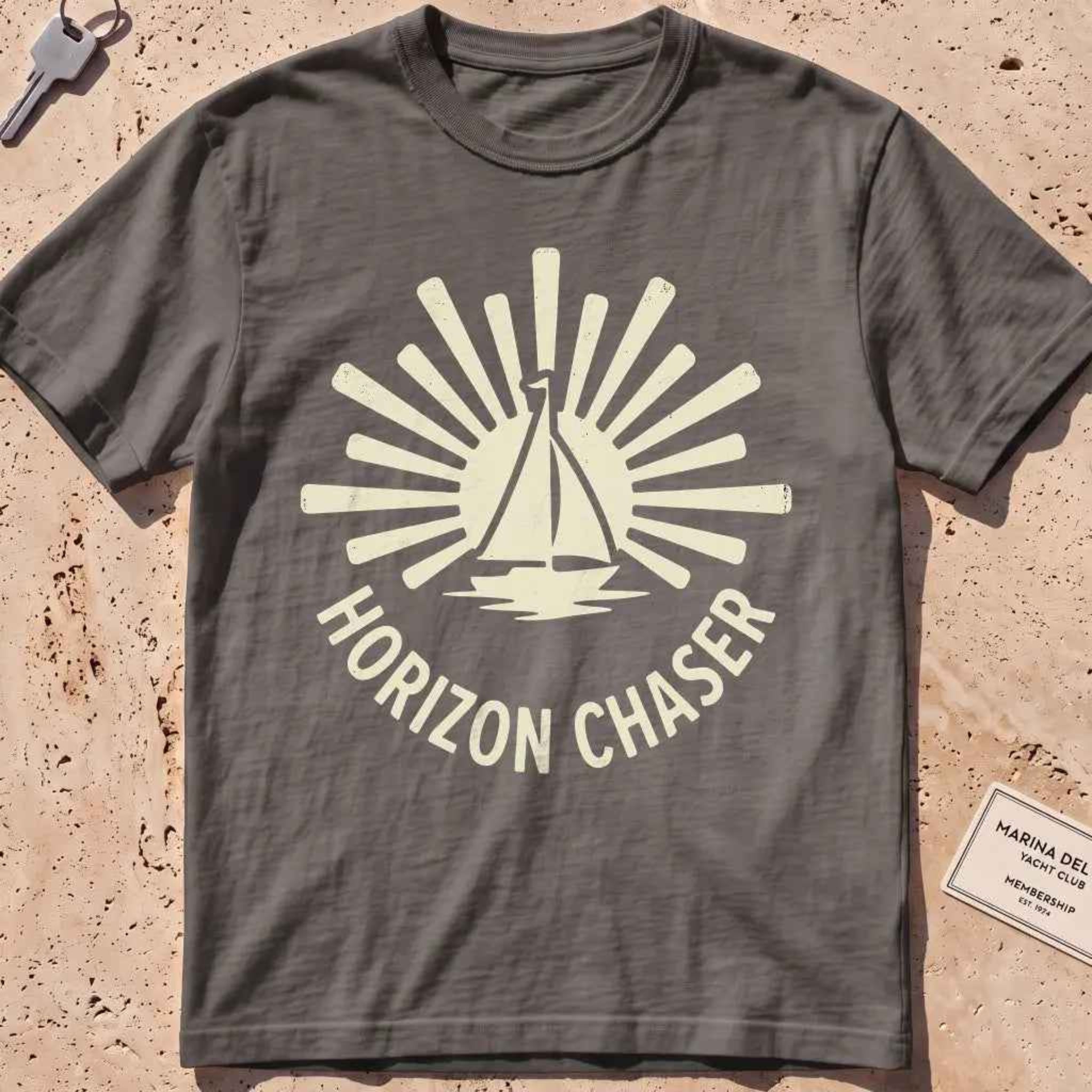 pepper heavyweight tee with a sunburst sailboat "Horizon Chaser" badge.