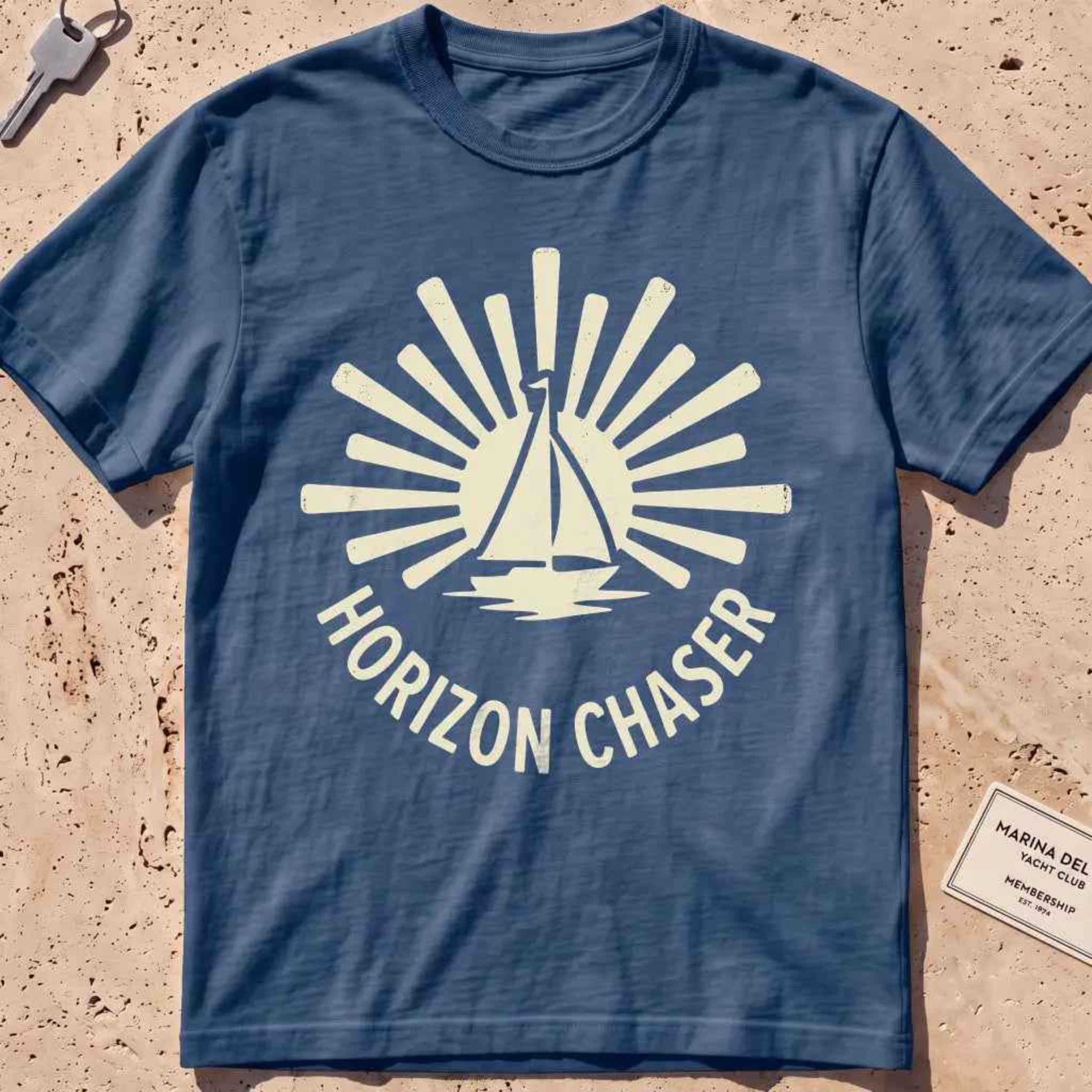 midnight heavyweight tee with a sunburst sailboat "Horizon Chaser" badge.