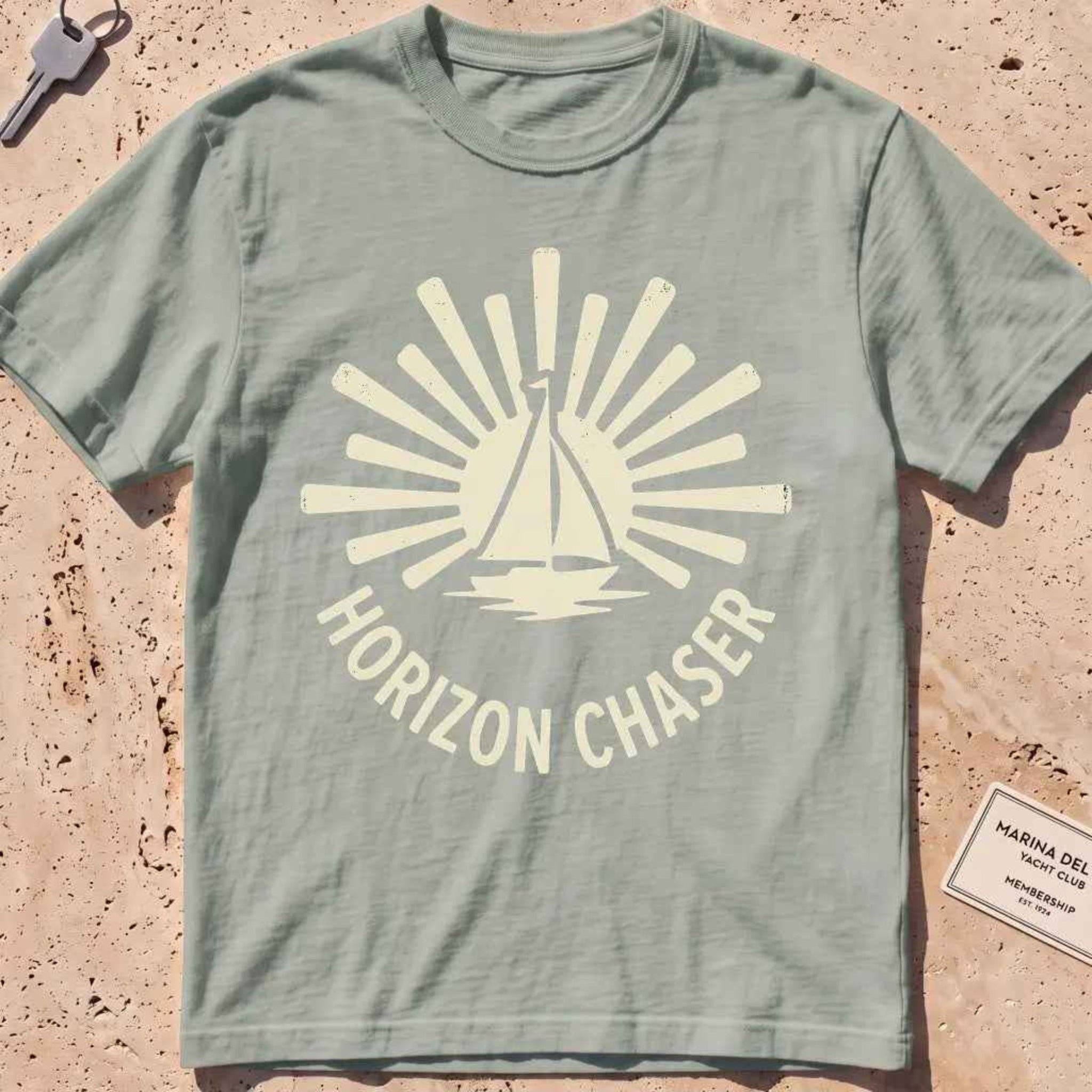 bay heavyweight tee with a sunburst sailboat "Horizon Chaser" badge.