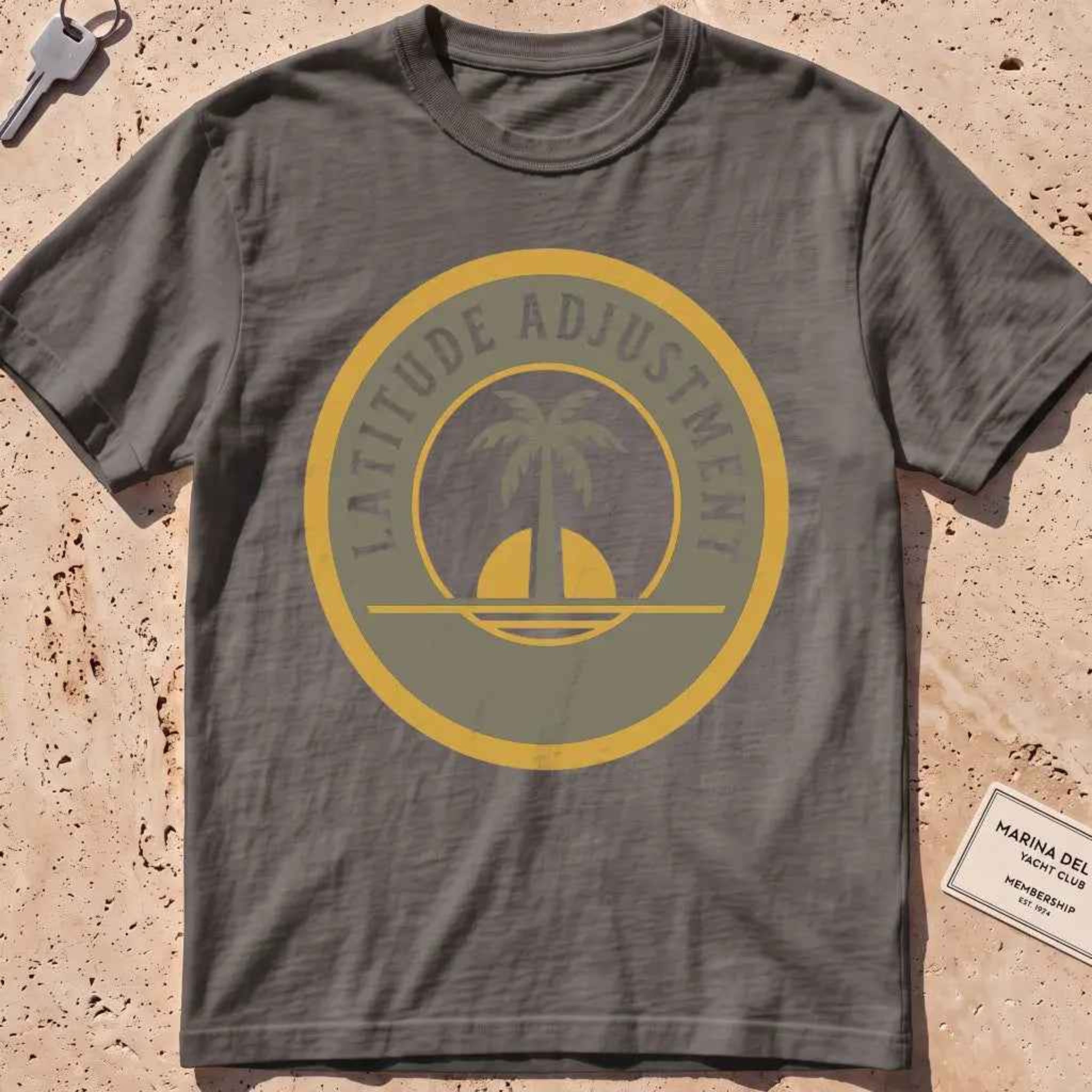 pepper heavyweight tee with a palm-and-sun "Latitude Adjustment" badge.
