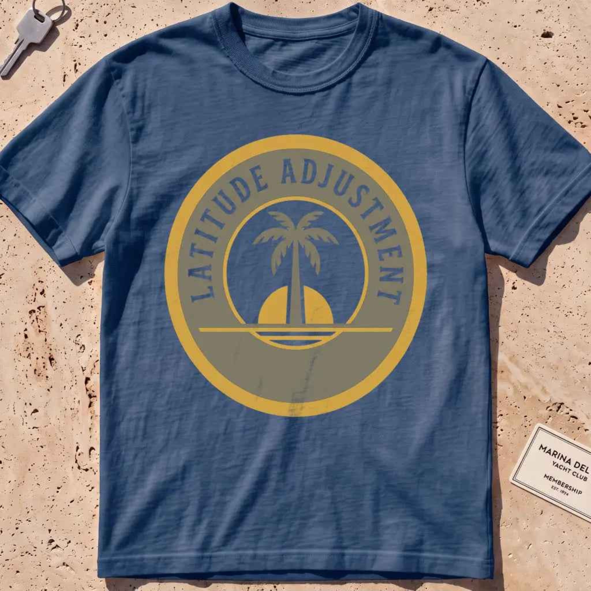 midnight heavyweight tee with a palm-and-sun "Latitude Adjustment" badge.