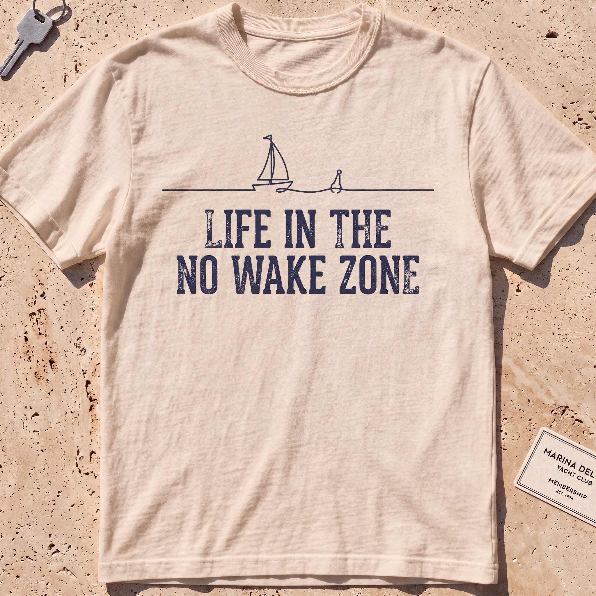 Ivory heavyweight tee with a single-line sailboat, buoy and "No Wake Zone" text.