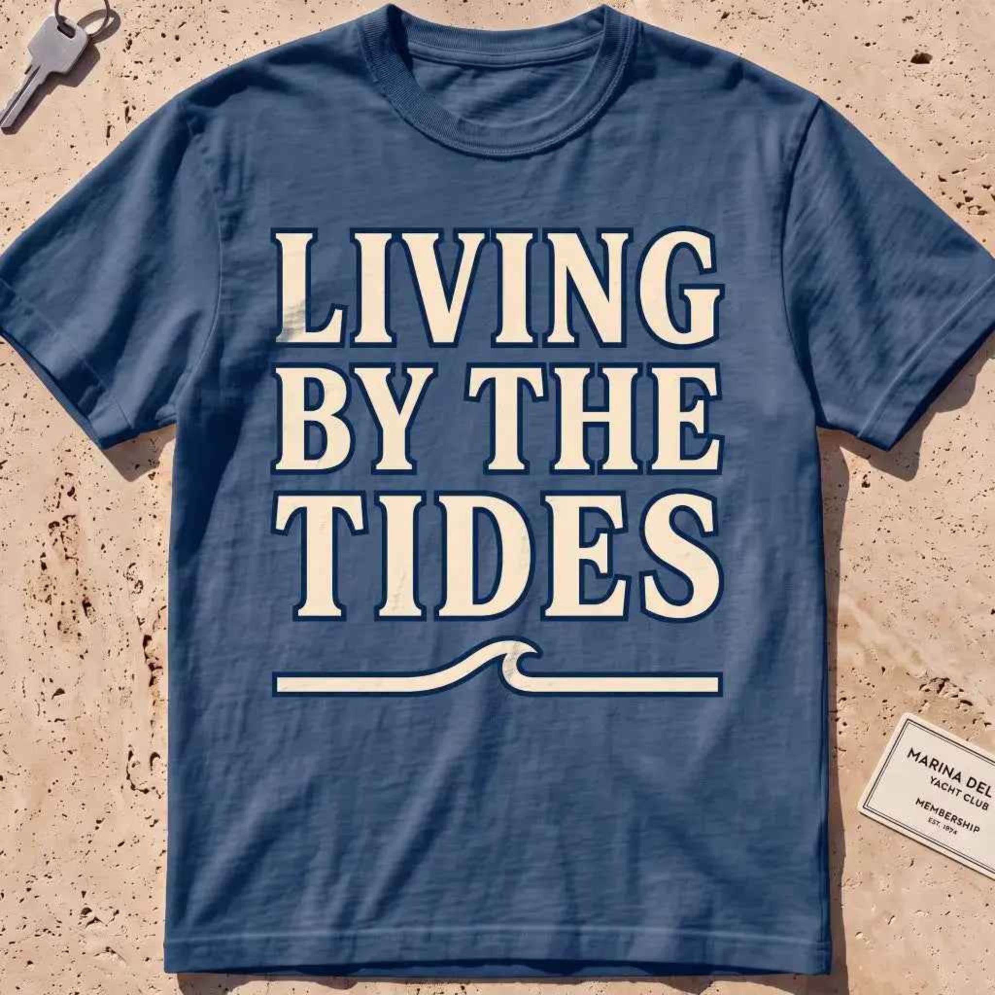 midnight heavyweight tee with "Living by the Tides" type over a swell rule.