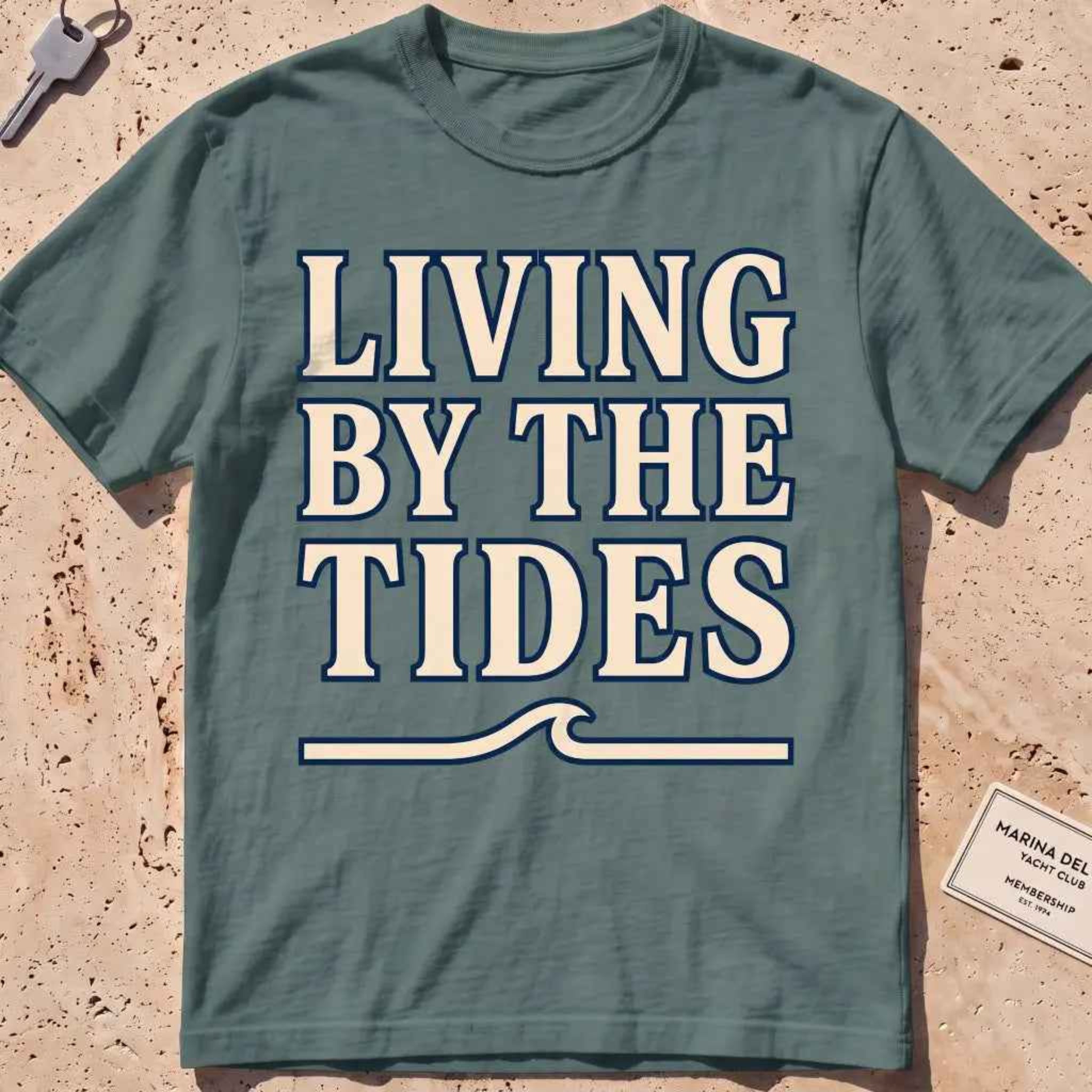 blue spruce heavyweight tee with "Living by the Tides" type over a swell rule.