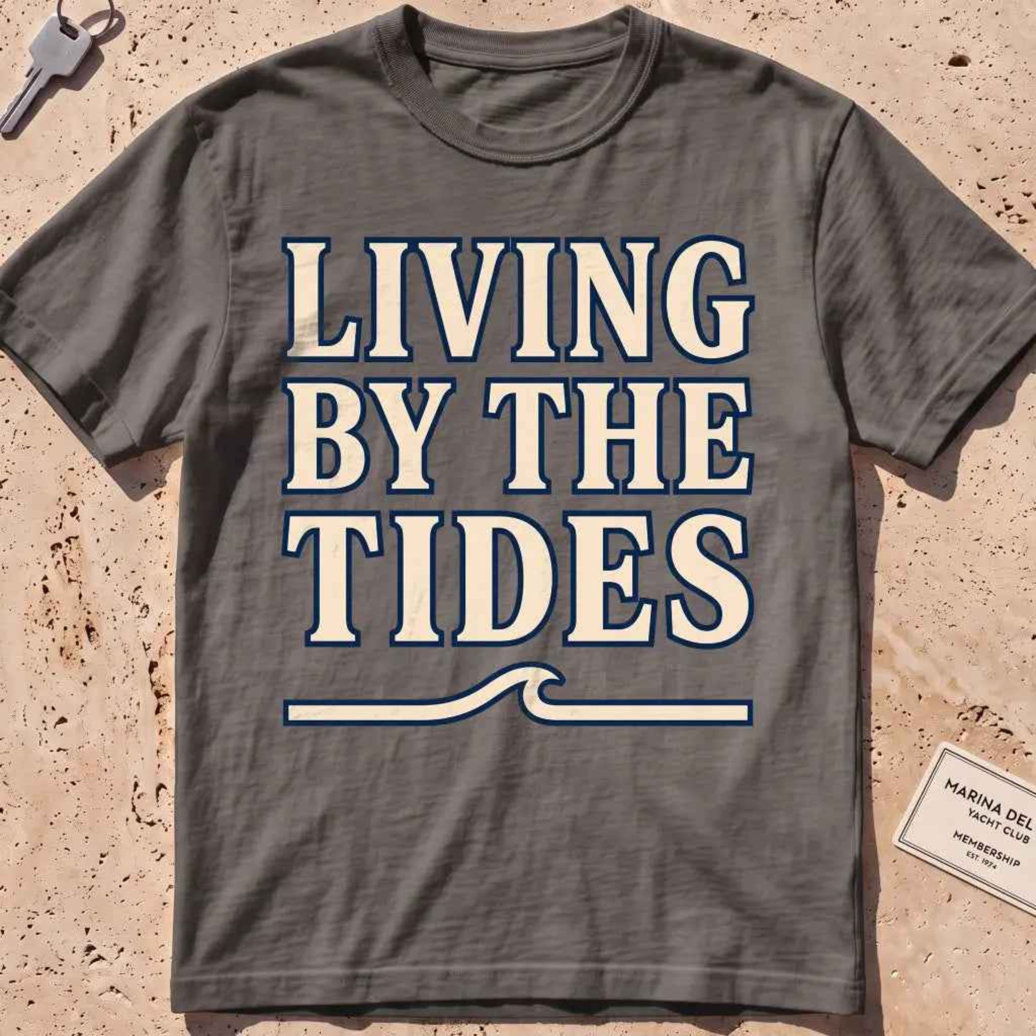pepper heavyweight tee with "Living by the Tides" type over a swell rule.
