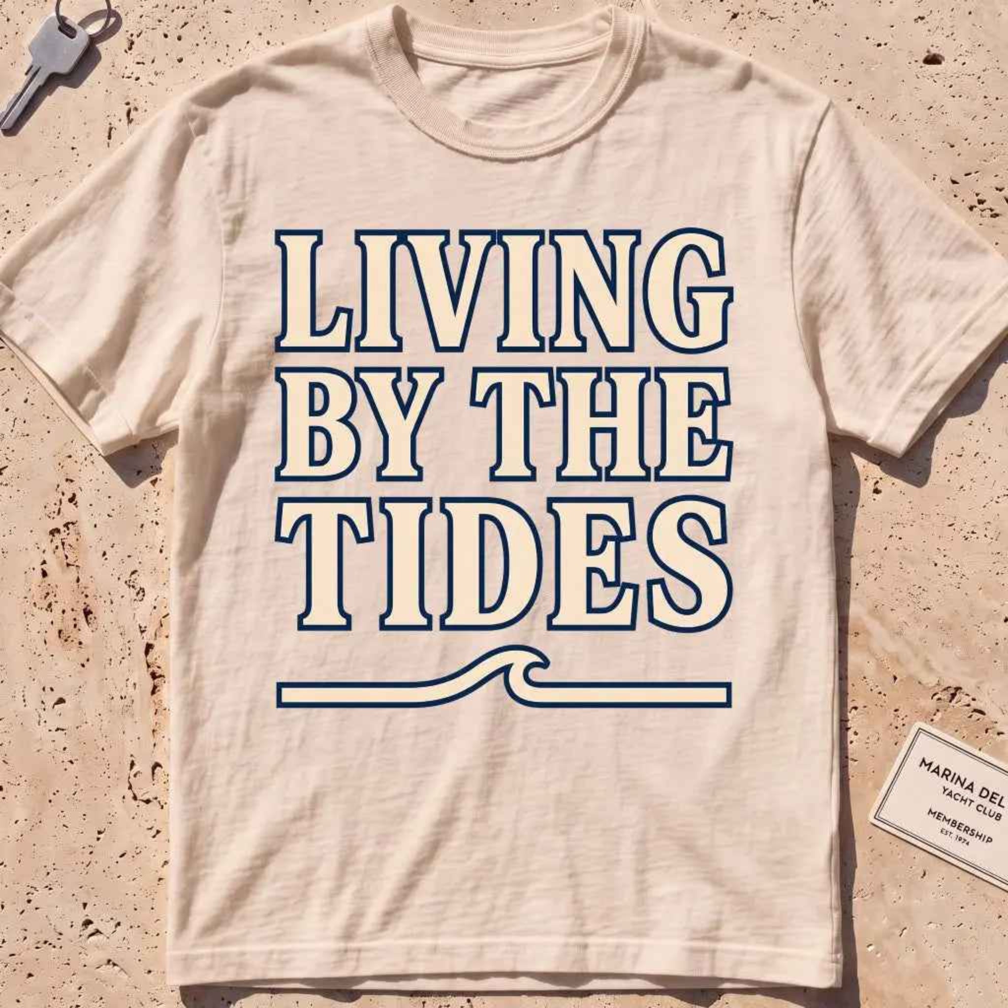 ivory heavyweight tee with "Living by the Tides" type over a swell rule.