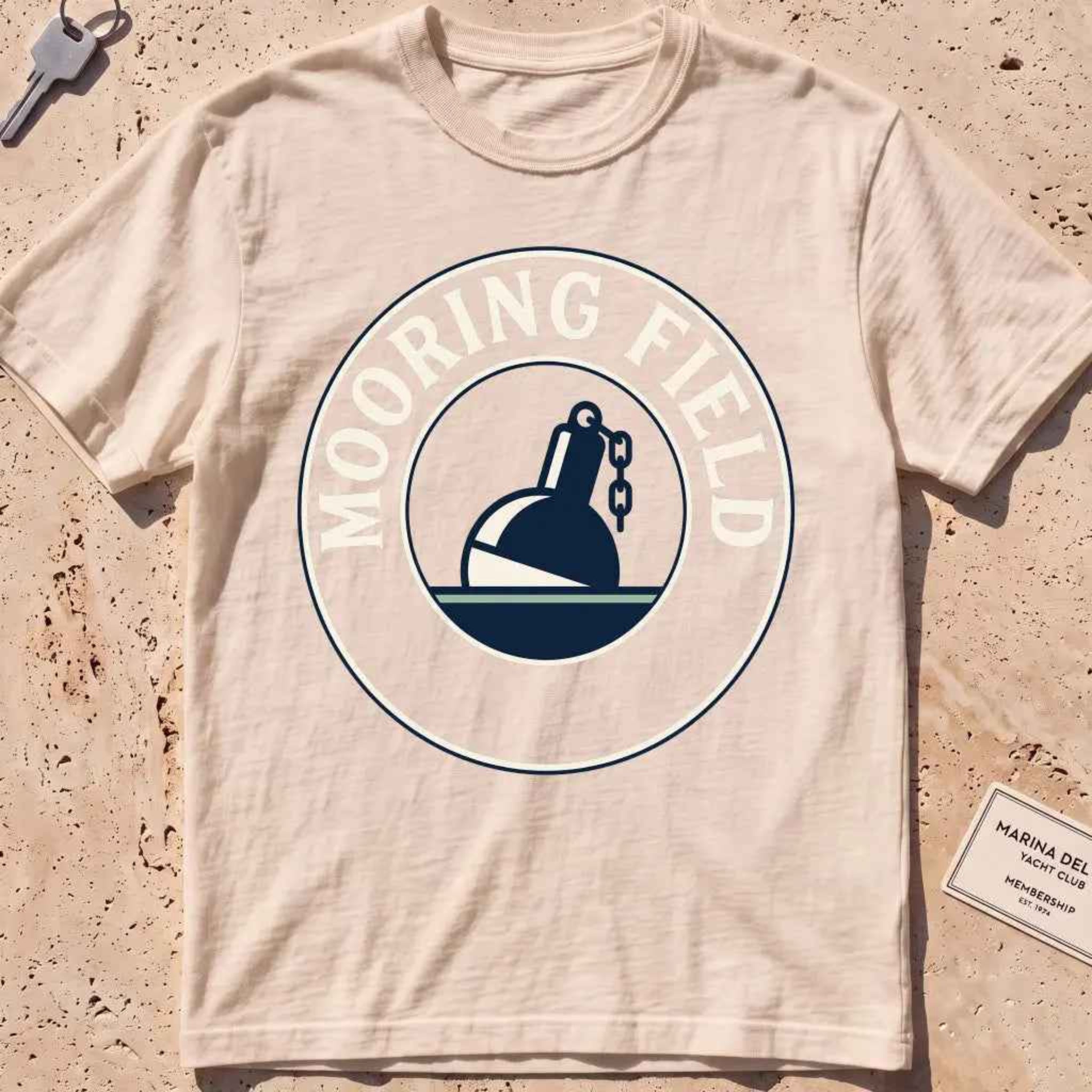 ivory heavyweight tee with a mooring buoy and chain harbor mooring-field badge graphic.
