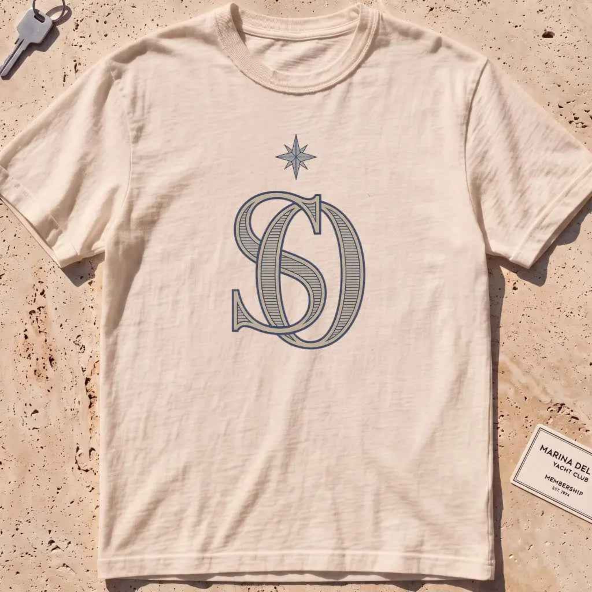 ivory heavyweight tee with an interlocking SO monogram and compass star.