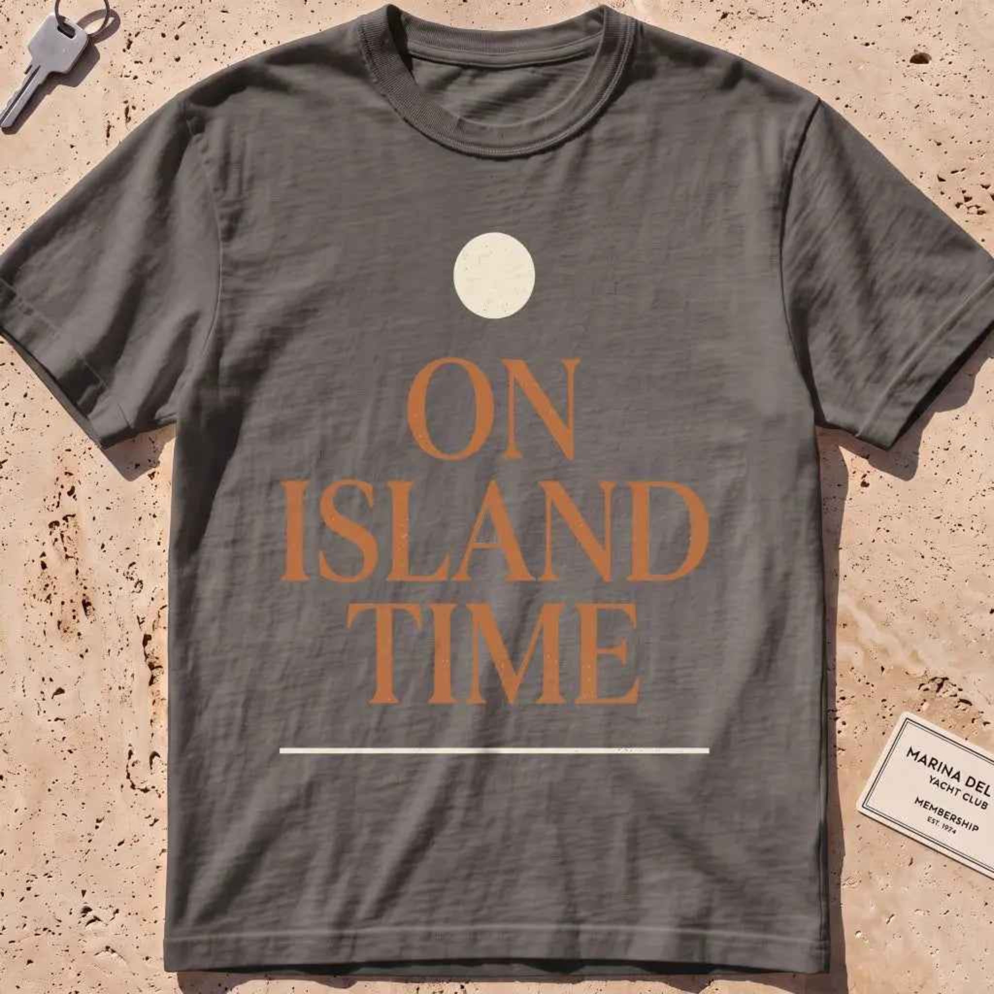 pepper heavyweight tee with terracotta "On Island Time" type and sun disc.