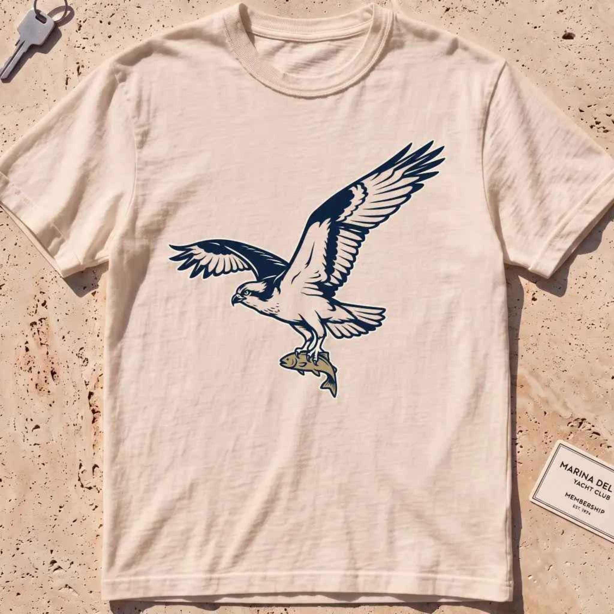 ivory heavyweight tee with a bold-fill osprey carrying a fish in its talons graphic.