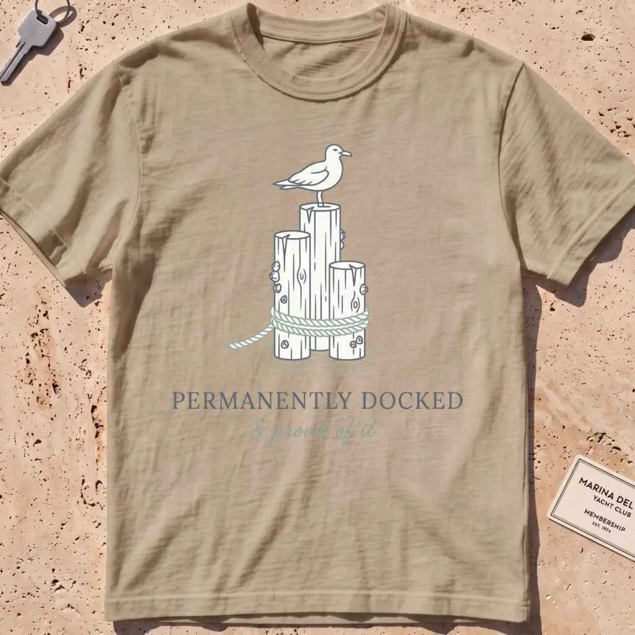 khaki heavyweight tee with dock pilings, a gull and "Permanently Docked" text.
