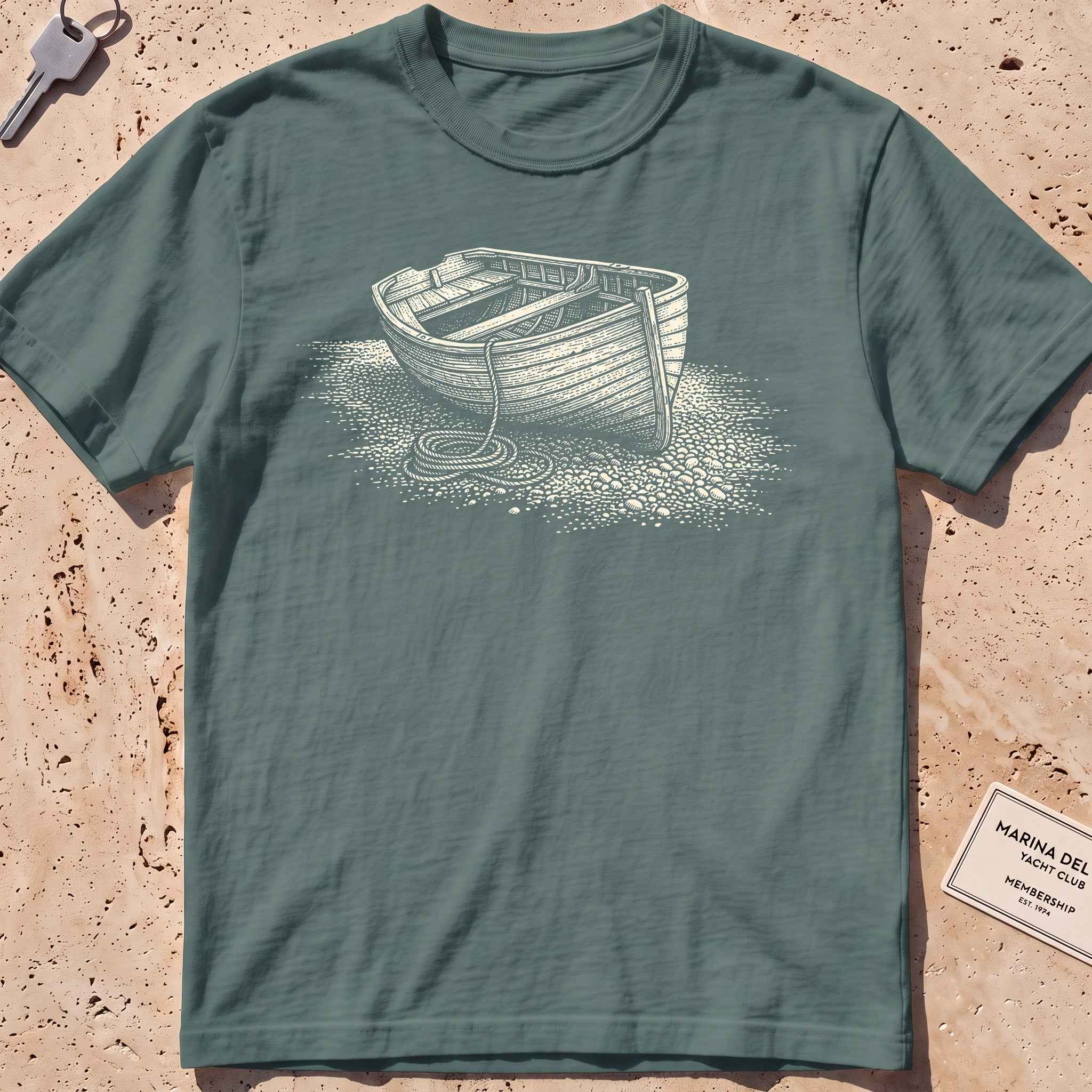 blue spruce heavyweight tee with an etched dinghy pulled ashore graphic