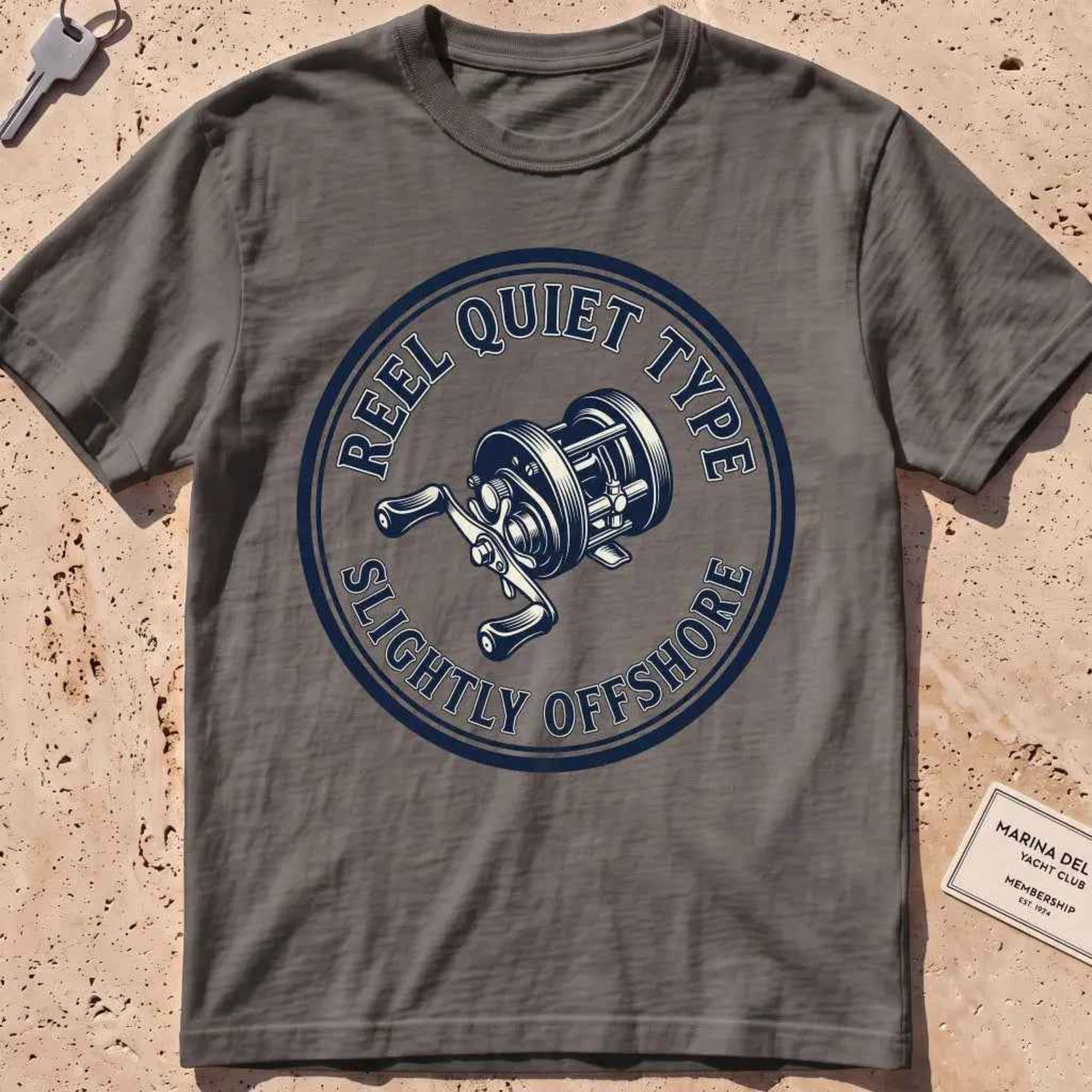 pepper heavyweight tee with an engraved fishing-reel "Reel Quiet Type" crest.