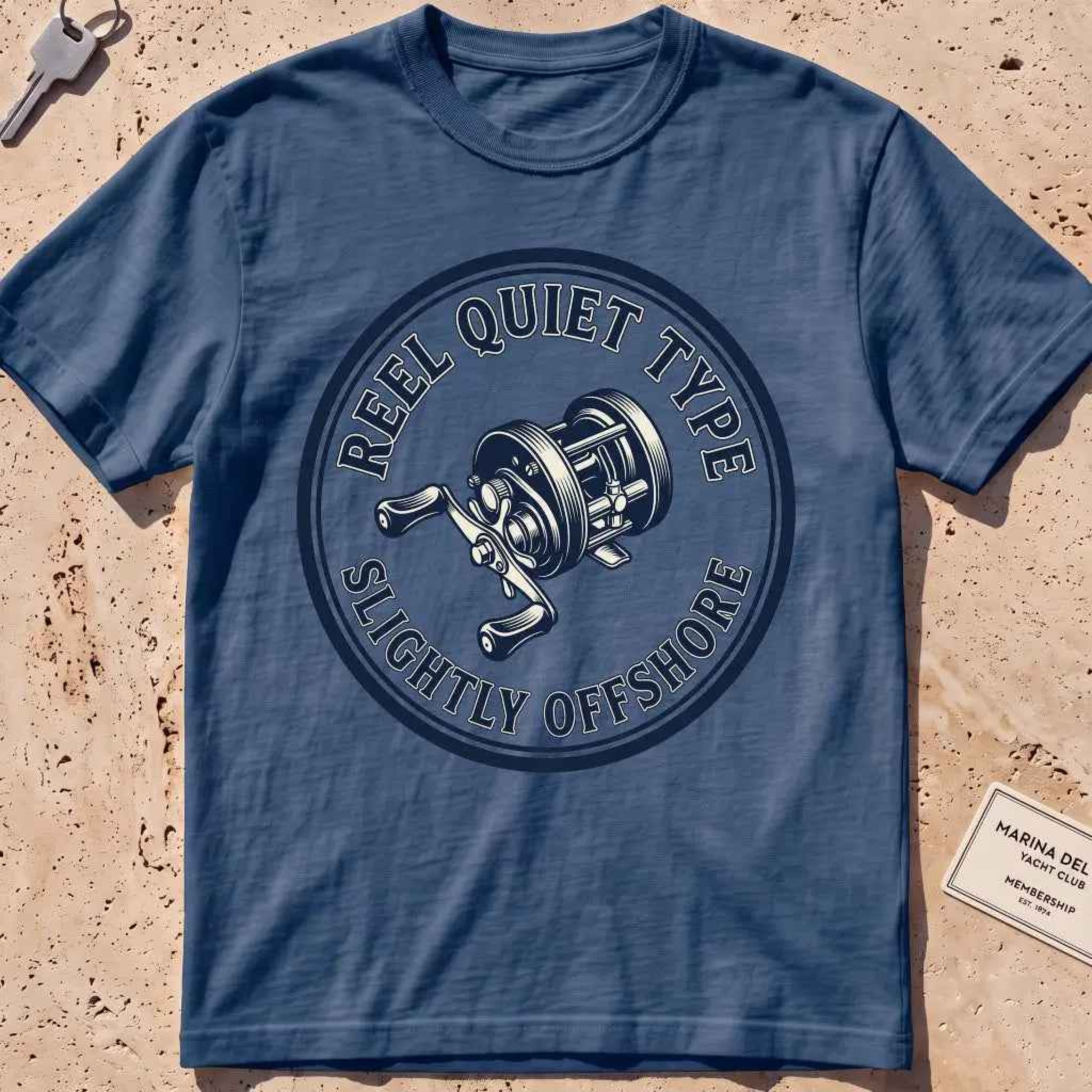 midnight heavyweight tee with an engraved fishing-reel "Reel Quiet Type" crest.