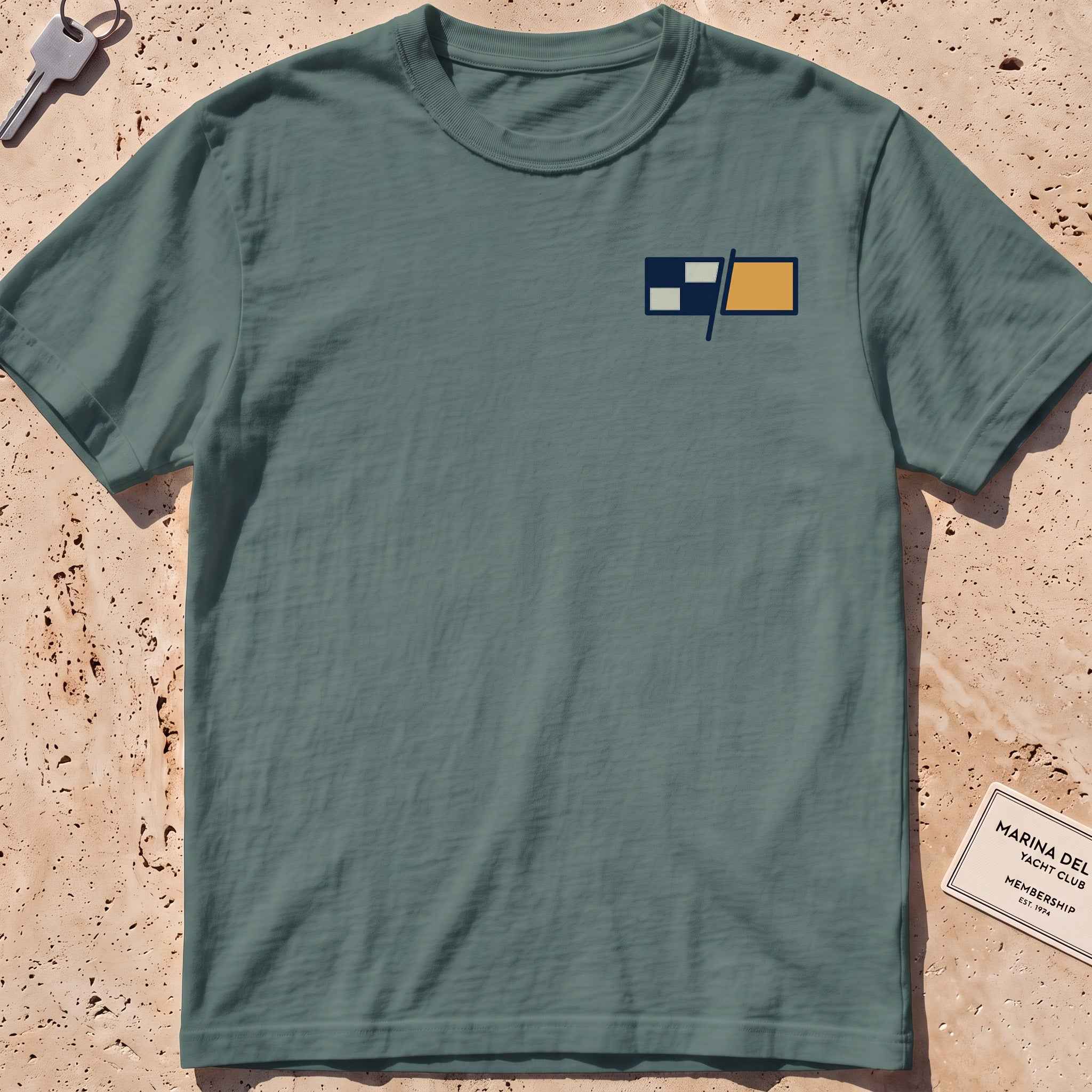 blue spruce heavyweight tee with a pair of maritime signal flags crest graphic.