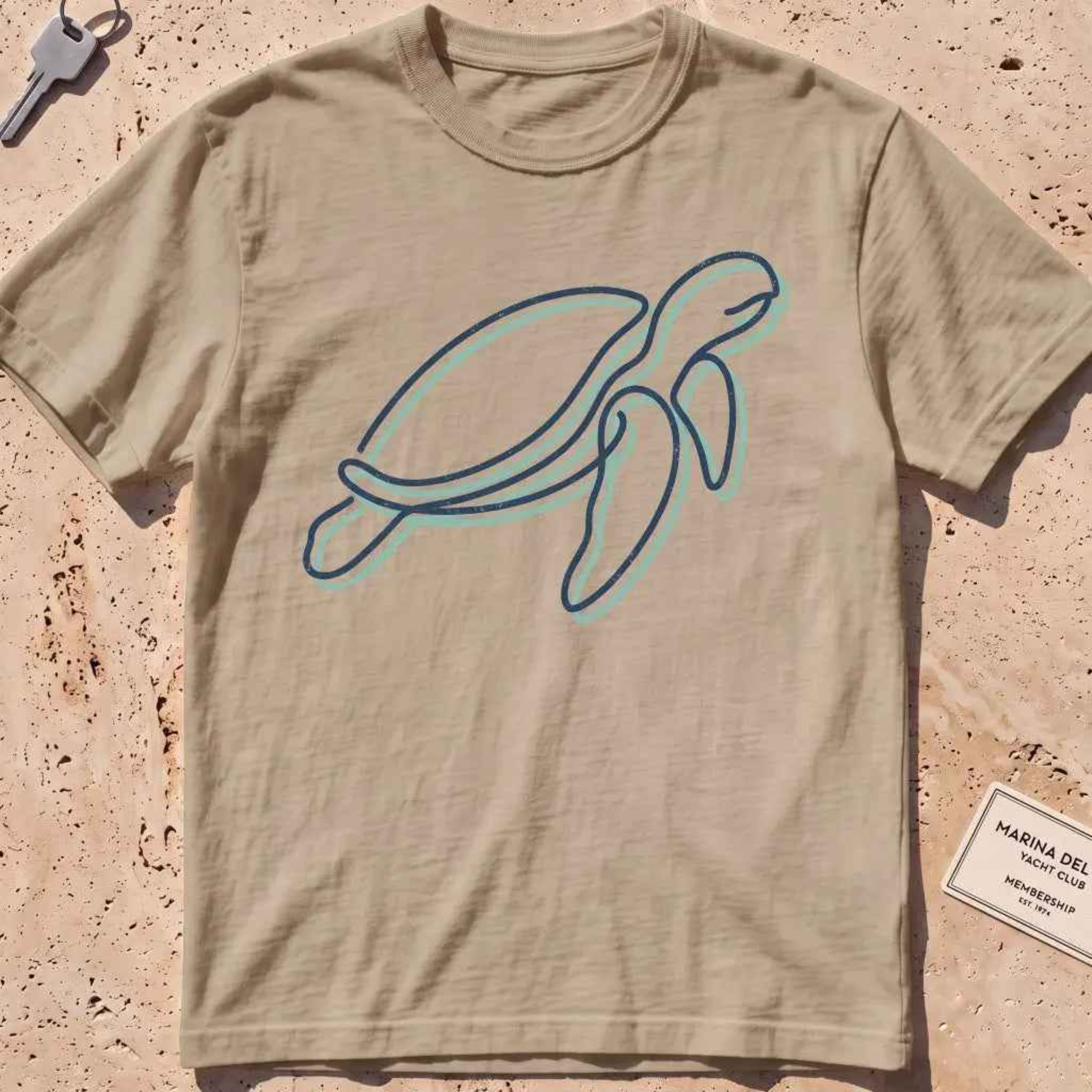 khaki heavyweight tee with a single continuous-line sea turtle graphic.