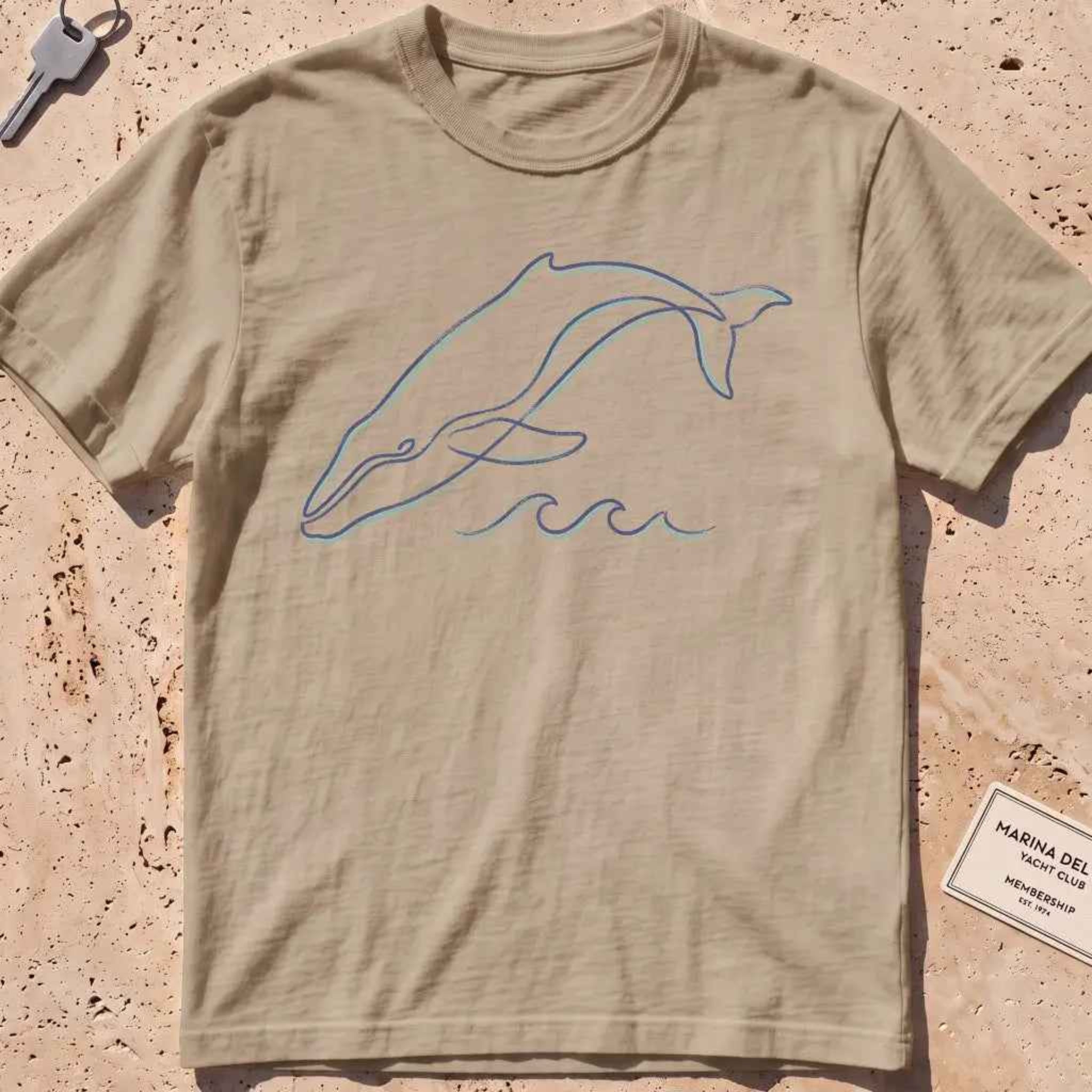 khaki heavyweight tee with a single continuous-line whale and wave graphic.