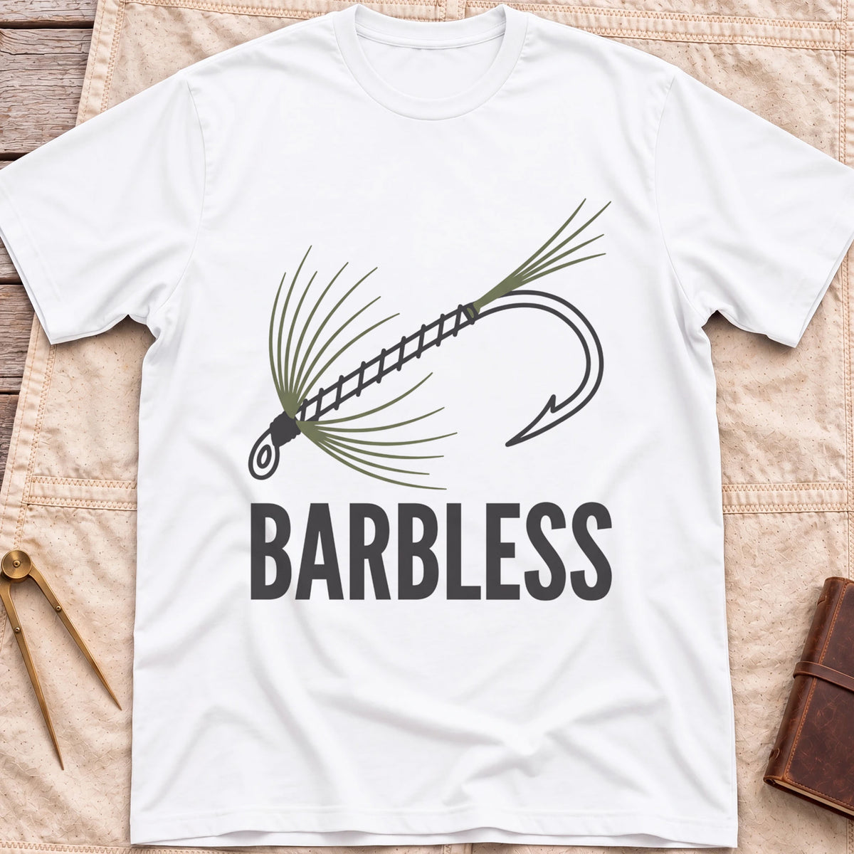 Front view of the white Barbless T-Shirt with a fly-fishing fly on a hook above the word Barbless.