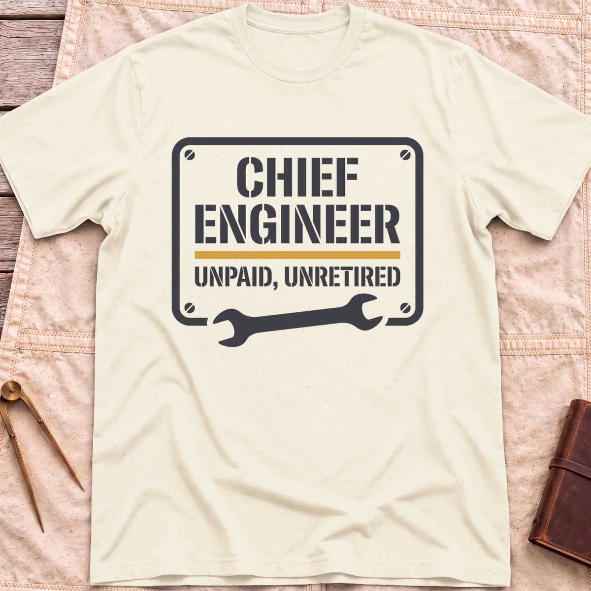 Front view of the natural Chief Engineer T-Shirt with a stencil-style plate reading Unpaid, Unretired above a wrench.