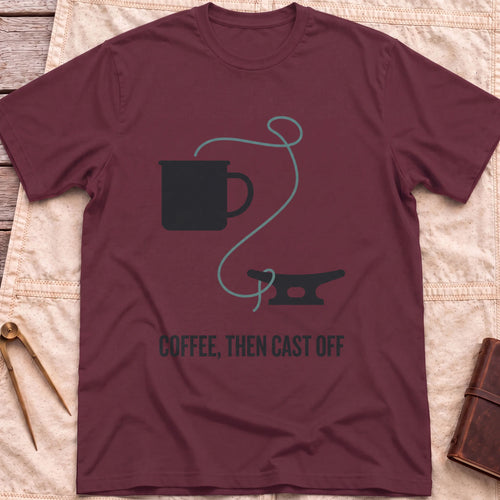 Front view of the maroon Coffee Then Cast Off T-Shirt with a mug and a single line trailing from it to a dock cleat.