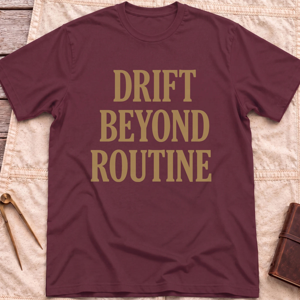 Front view of the maroon Drift Beyond Routine T-Shirt with the words Drift Beyond Routine in large tan capitals.