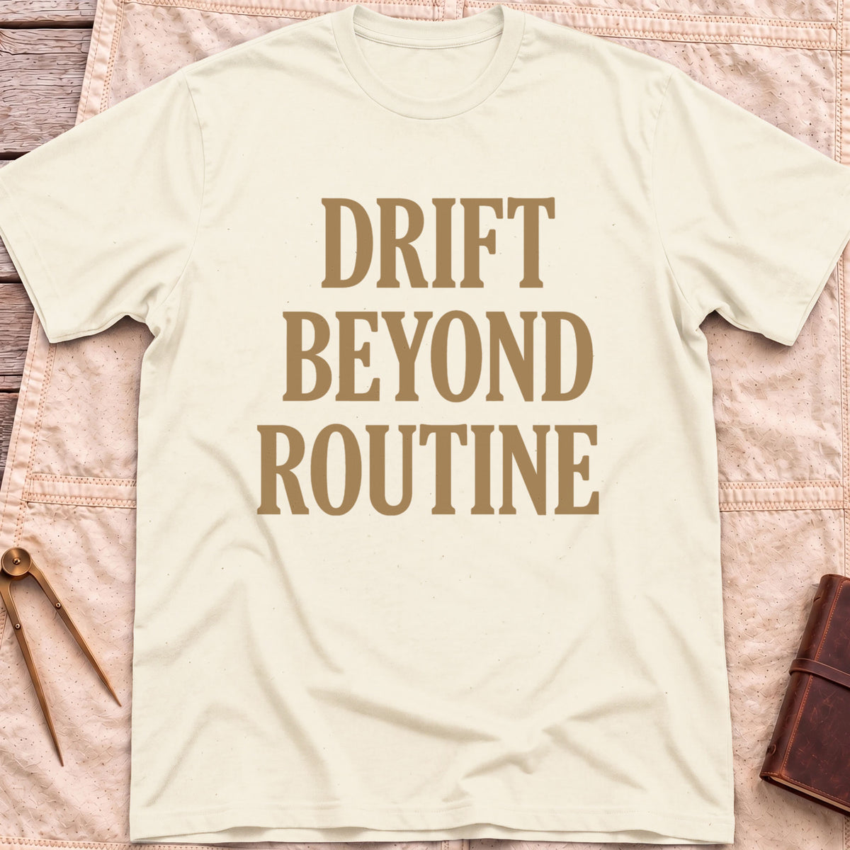 Front view of the natural Drift Beyond Routine T-Shirt with the words Drift Beyond Routine in large tan capitals.